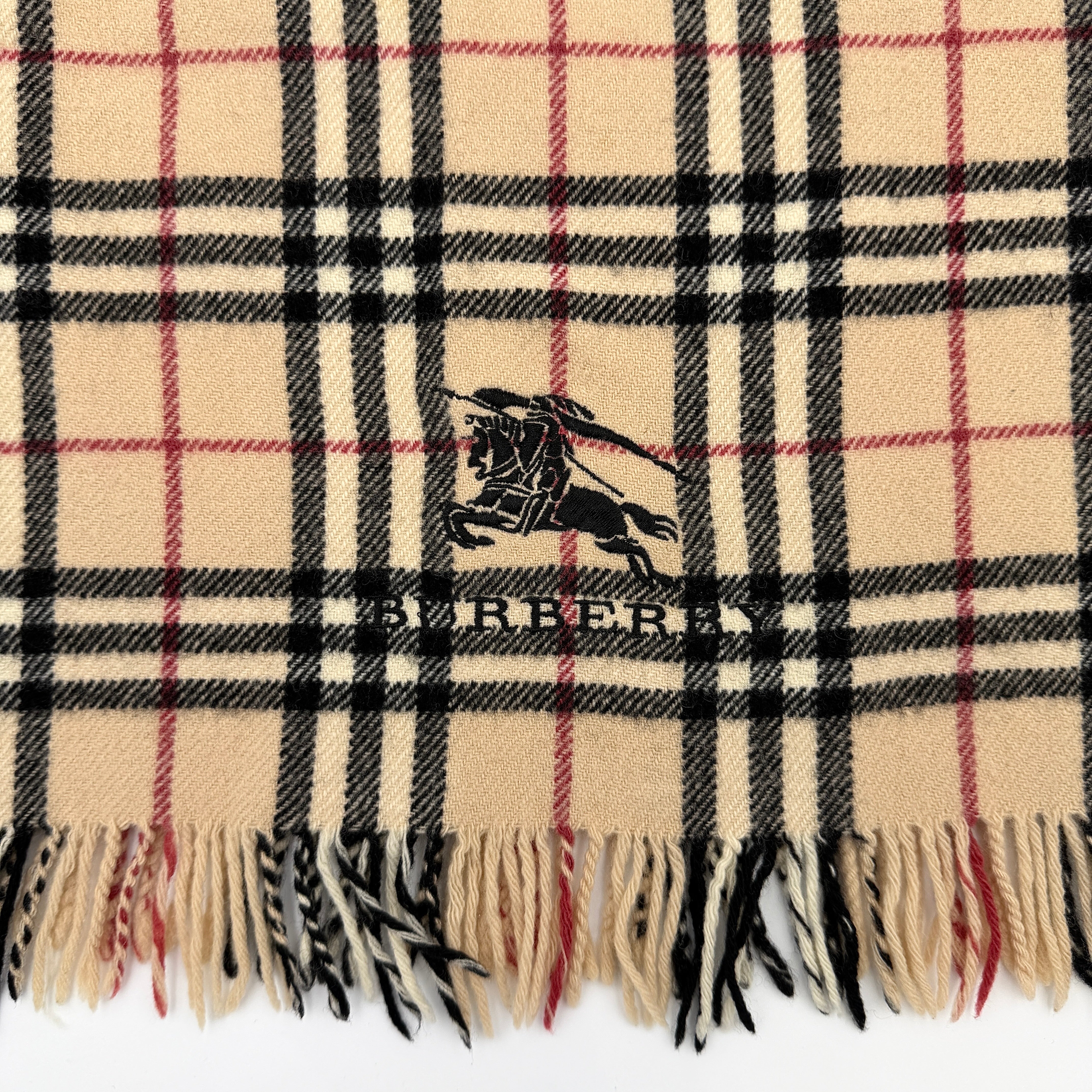 Burberry Nova Check wool scarf with fringed edges and embroidered logo in a beige, black, and red tartan pattern.