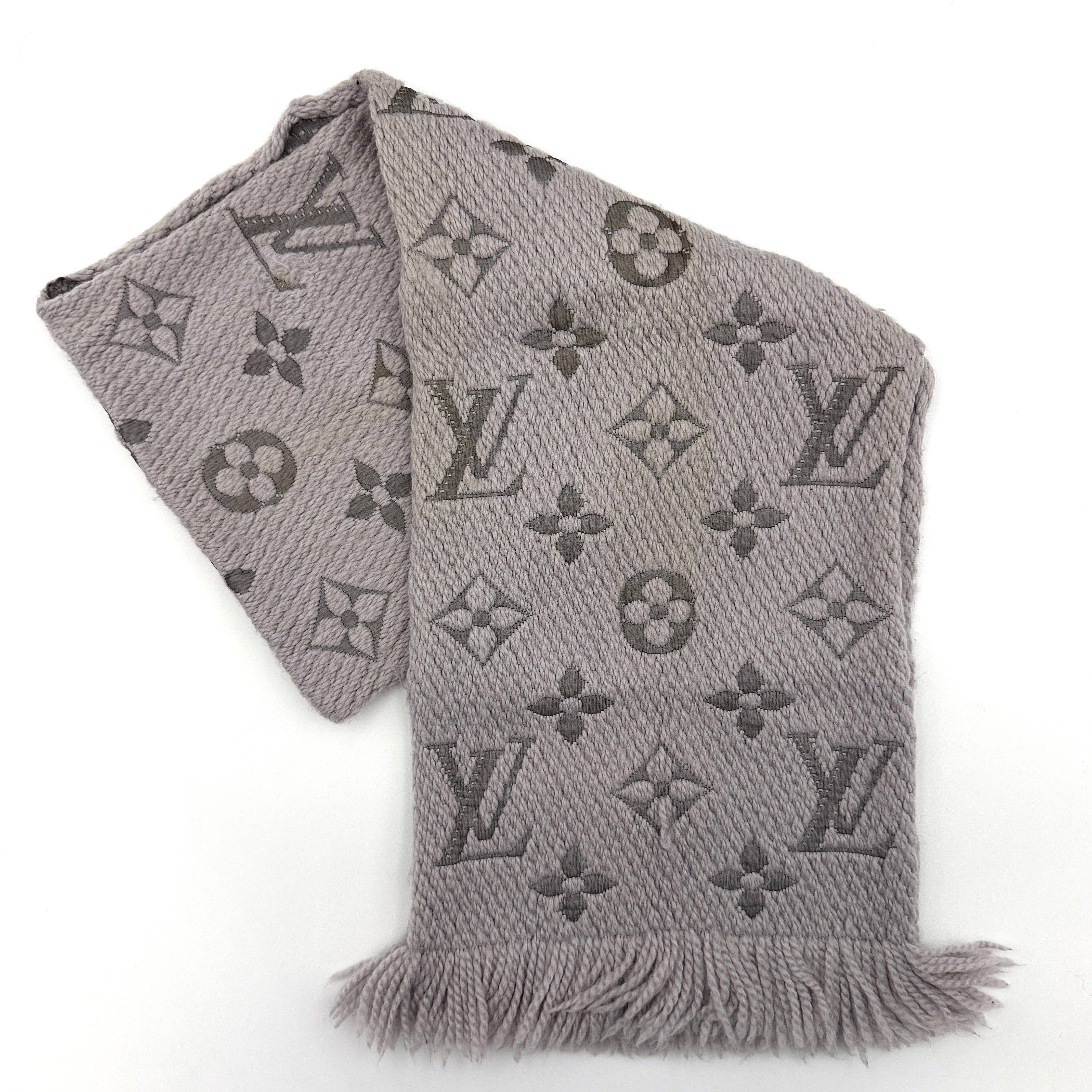 Louis Vuitton grey wool scarf featuring an all-over monogram pattern with soft fringed edges, elegantly draped for a premium look.