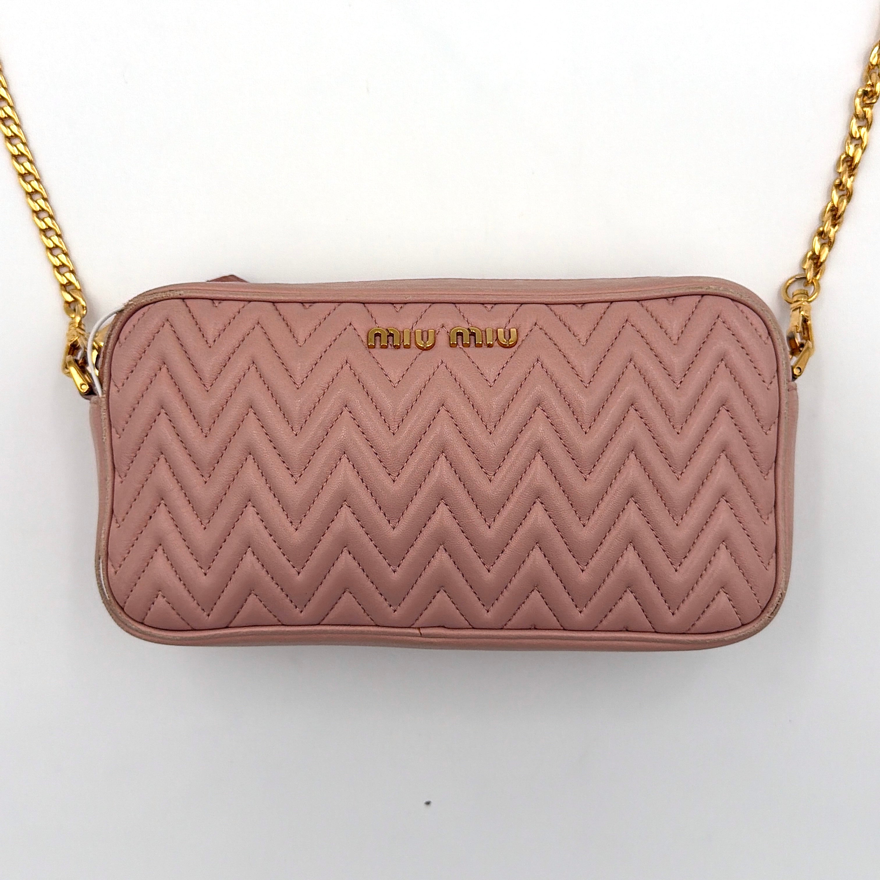 Miu Miu dusty pink quilted nappa mini crossbody bag with gold-tone chain strap and zip closure, showcased on a clean white background.