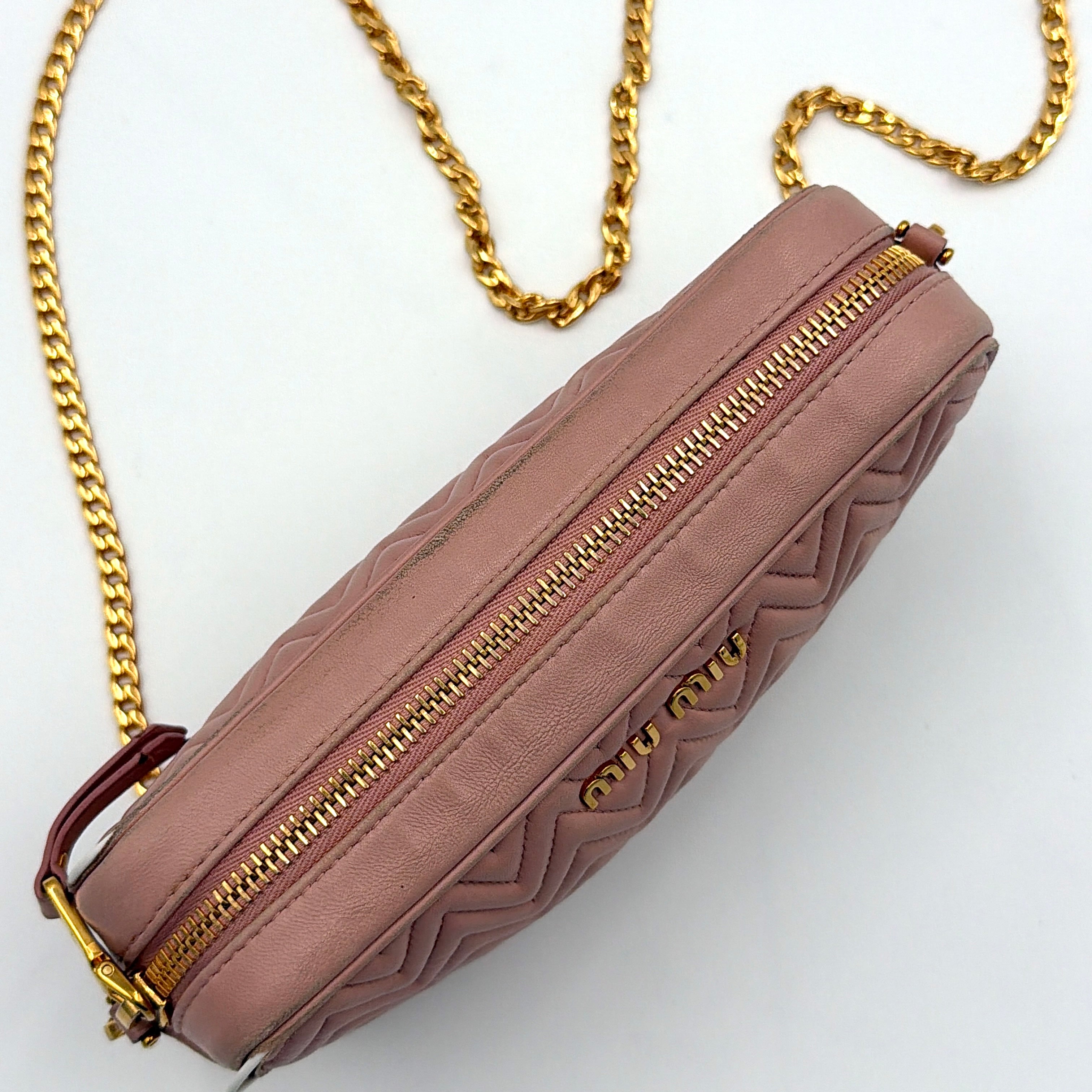 Miu Miu dusty pink quilted nappa mini crossbody bag with gold-tone chain strap and zip closure, showcased on a clean white background.