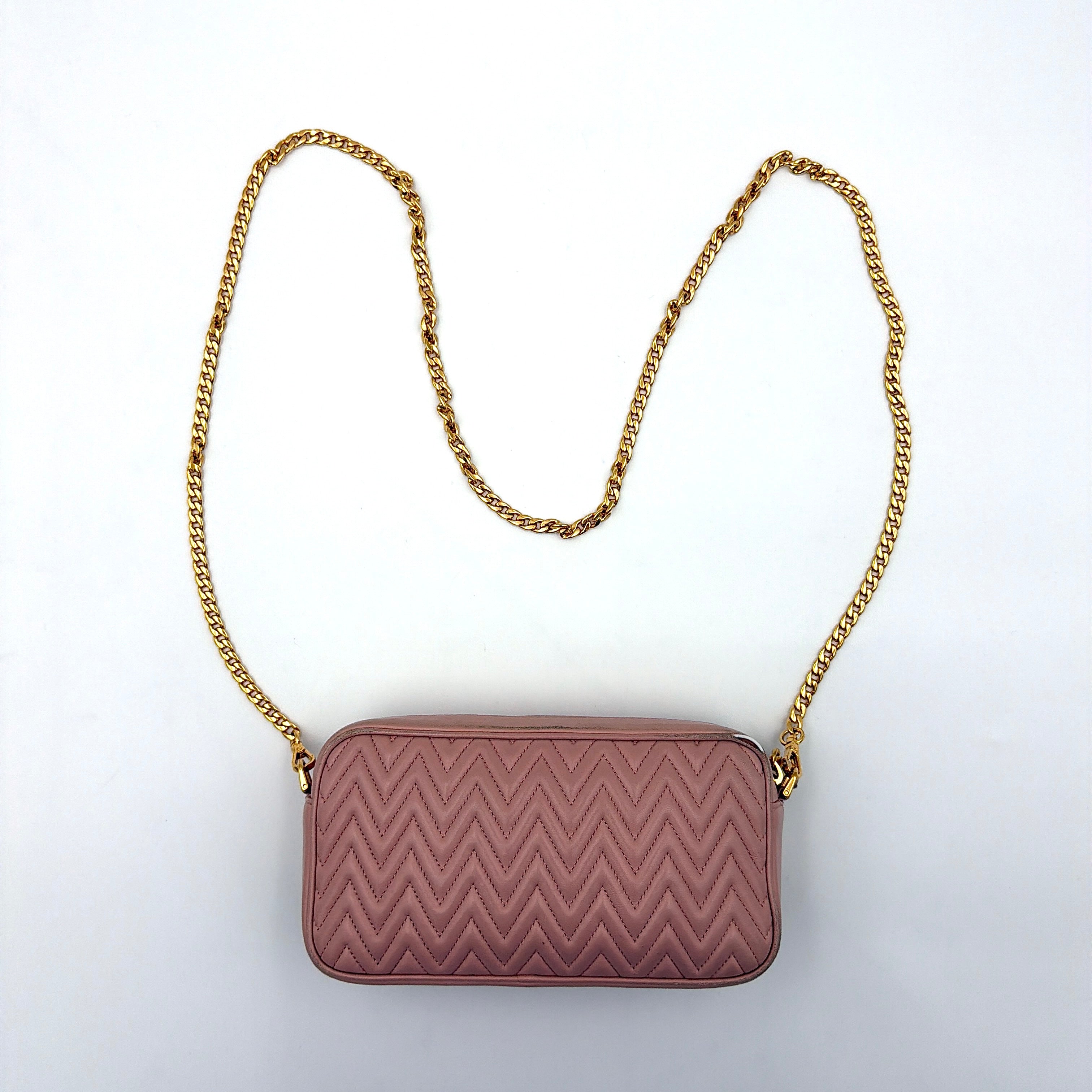 Miu Miu dusty pink quilted nappa mini crossbody bag with gold-tone chain strap and zip closure, showcased on a clean white background.