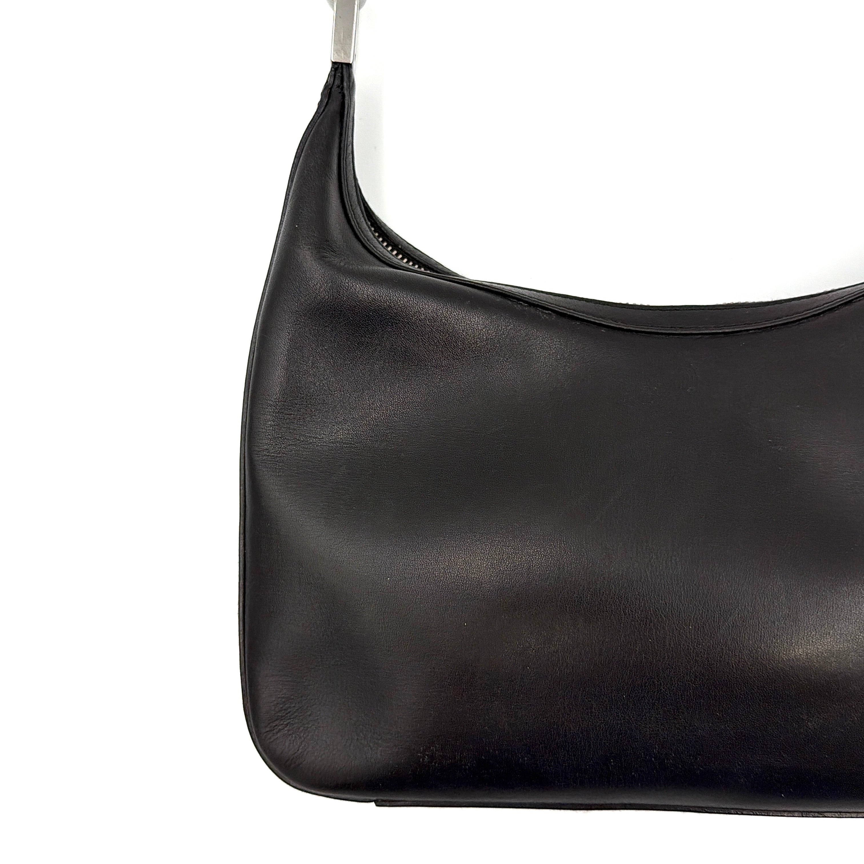 Gucci GG Leather Hobo Shoulder Bag in black smooth leather with sculptural silver-tone hardware and signature GG zip pull.