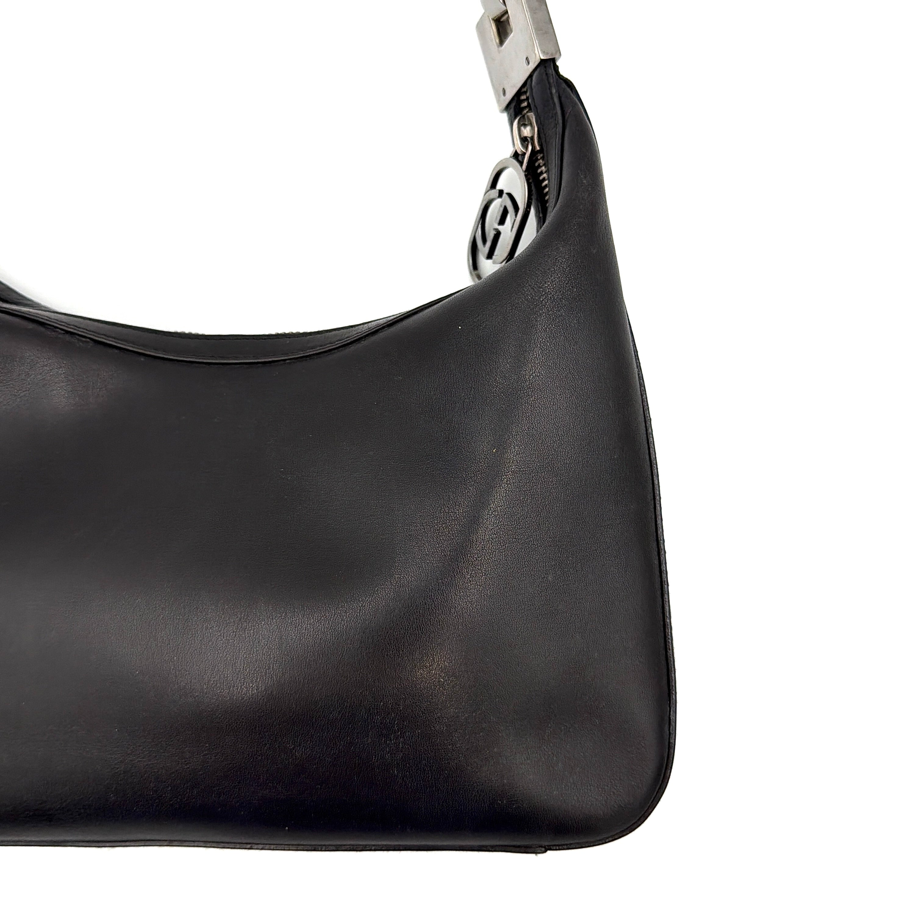 Gucci GG Leather Hobo Shoulder Bag in black smooth leather with sculptural silver-tone hardware and signature GG zip pull.