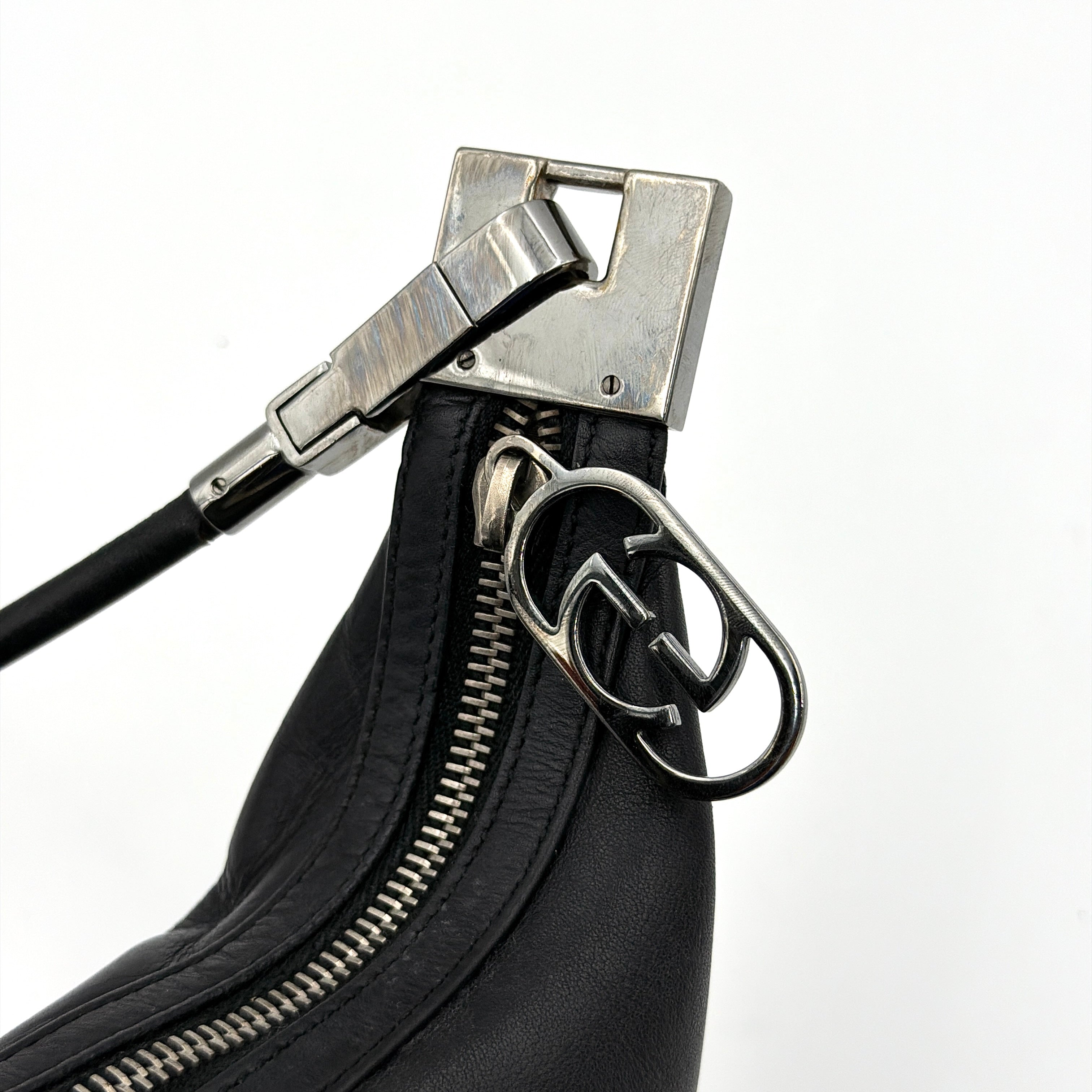 Gucci GG Leather Hobo Shoulder Bag in black smooth leather with sculptural silver-tone hardware and signature GG zip pull.