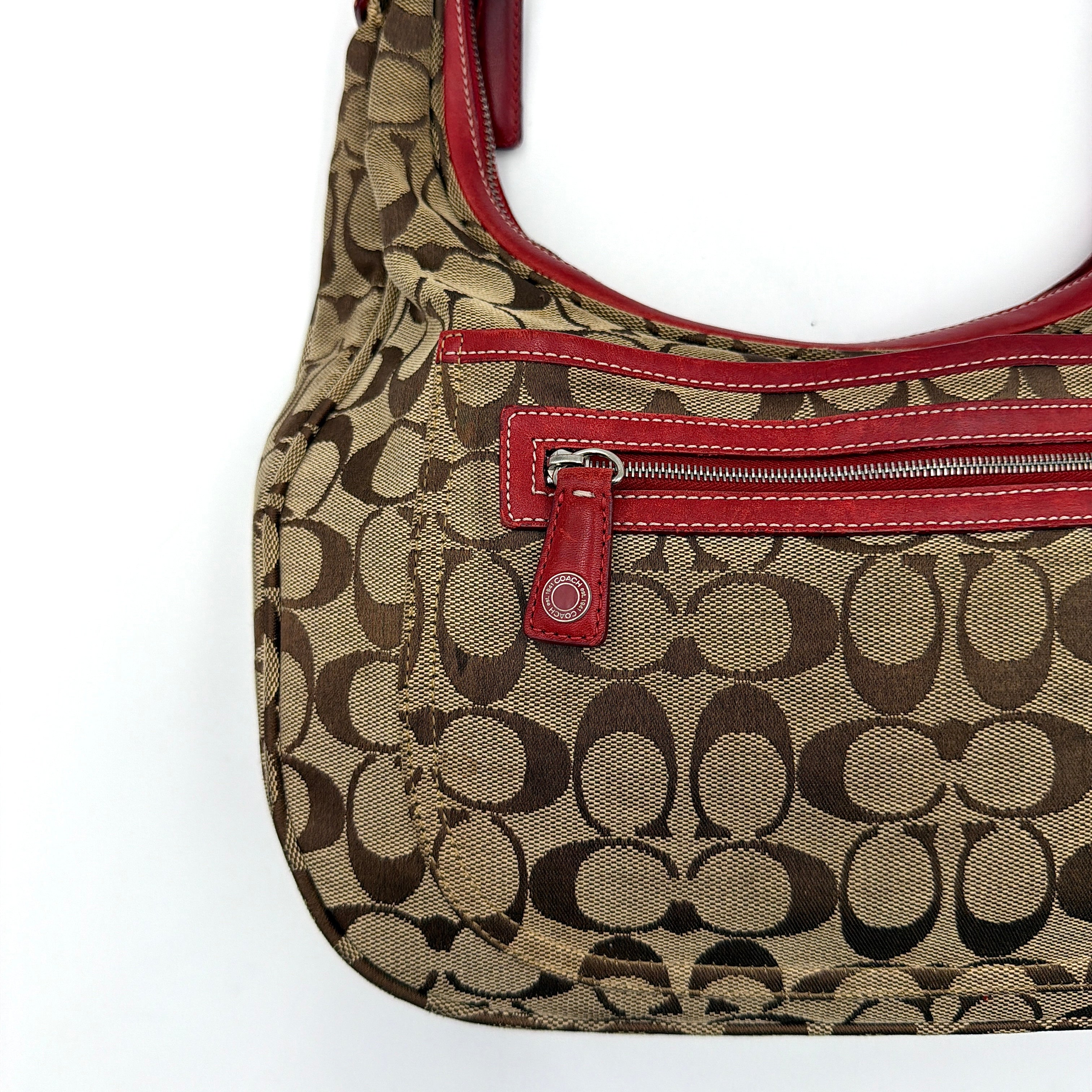 Coach Signature Hamilton Hobo Shoulder Bag in beige monogram canvas with striking red leather trim and a wide hobo silhouette.