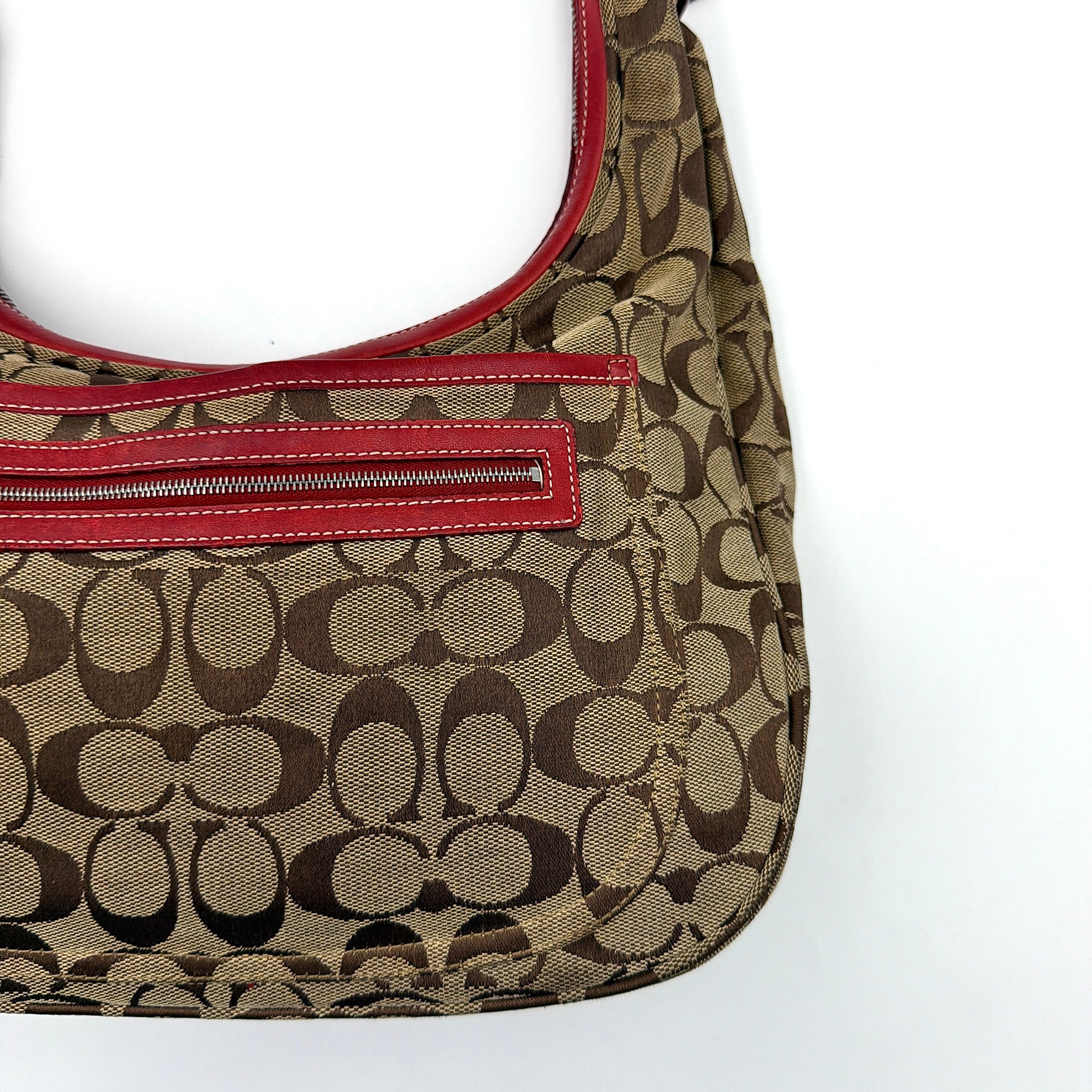 Coach Signature Hamilton Hobo Shoulder Bag in beige monogram canvas with striking red leather trim and a wide hobo silhouette.