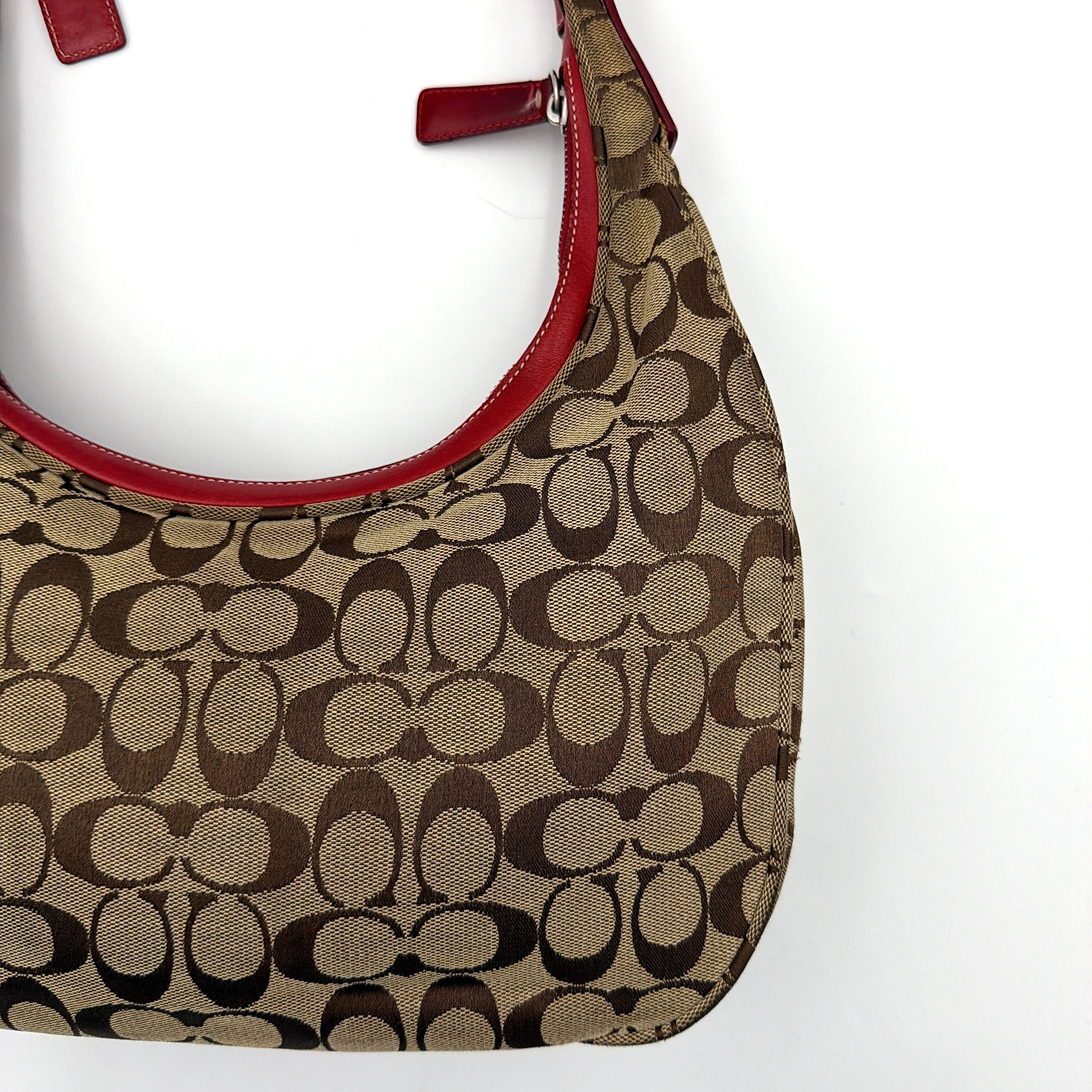 Coach Signature Hamilton Hobo Shoulder Bag in beige monogram canvas with striking red leather trim and a wide hobo silhouette.