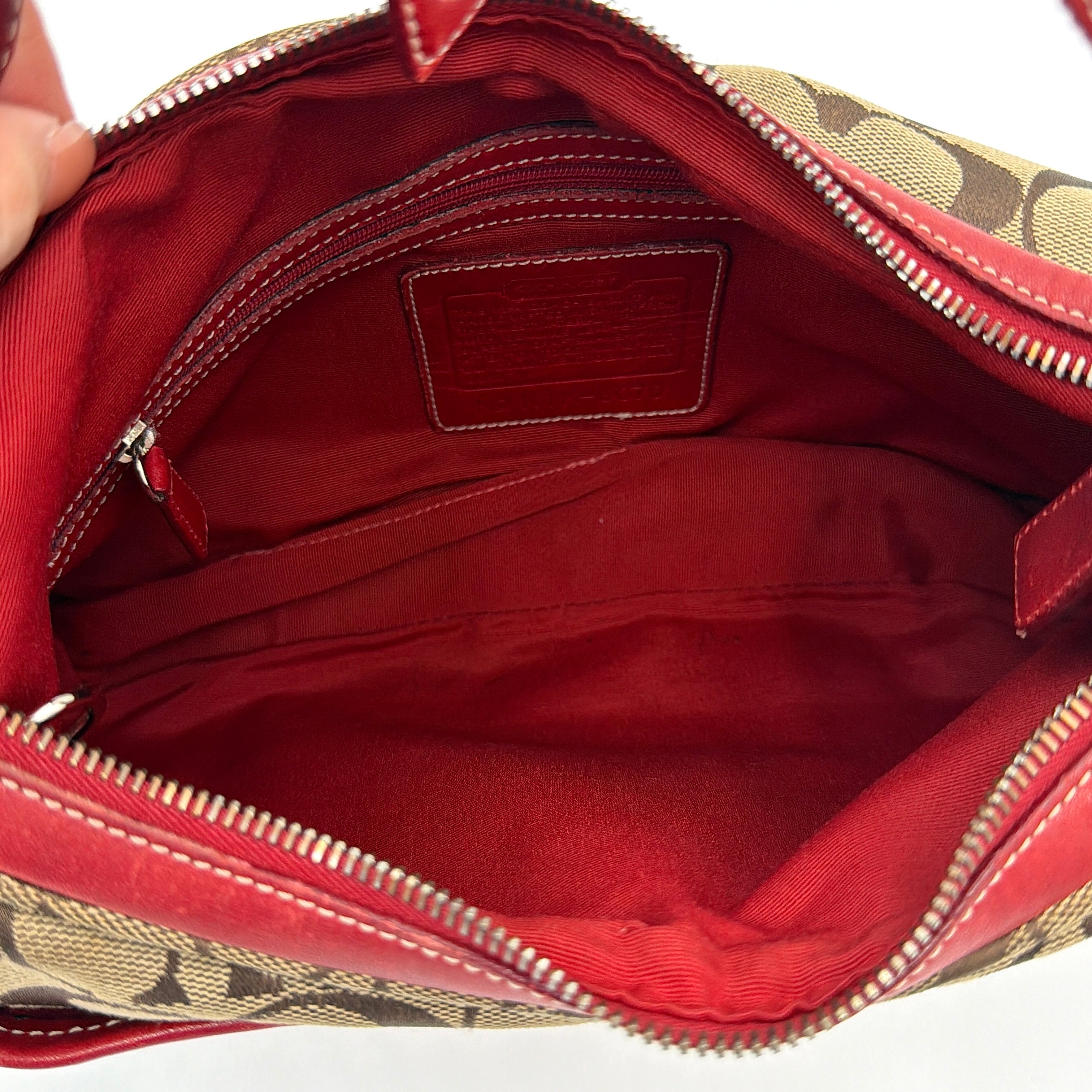 Coach Signature Hamilton Hobo Shoulder Bag in beige monogram canvas with striking red leather trim and a wide hobo silhouette.