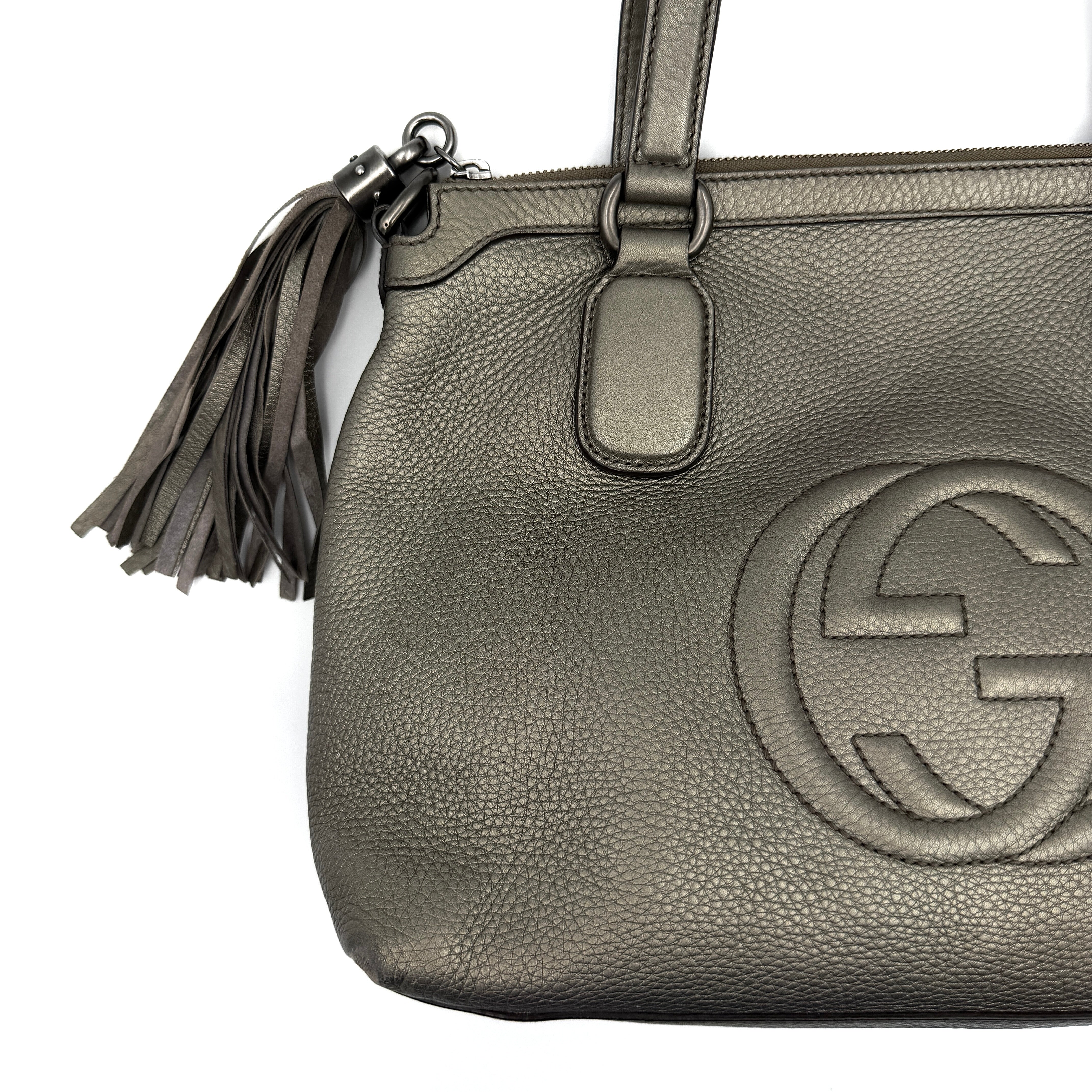 Gucci GG Soho Shoulder Bag in grey pebbled leather, featuring dual top handles, oversized stitched GG logo, and a leather tassel zip pull.