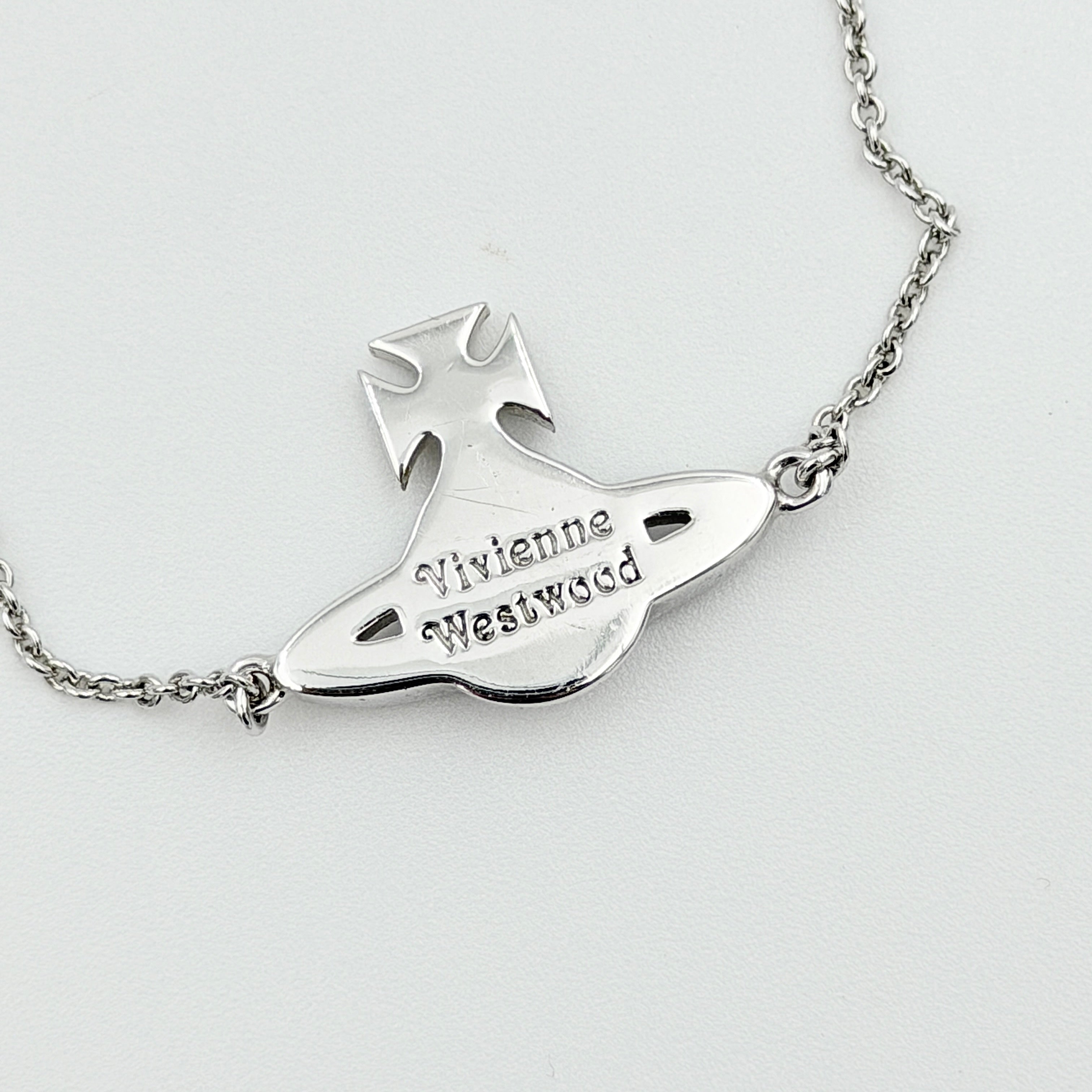 Vivienne Westwood silver rhinestone Orb bracelet with delicate chain and branded tag, shown against a clean background.