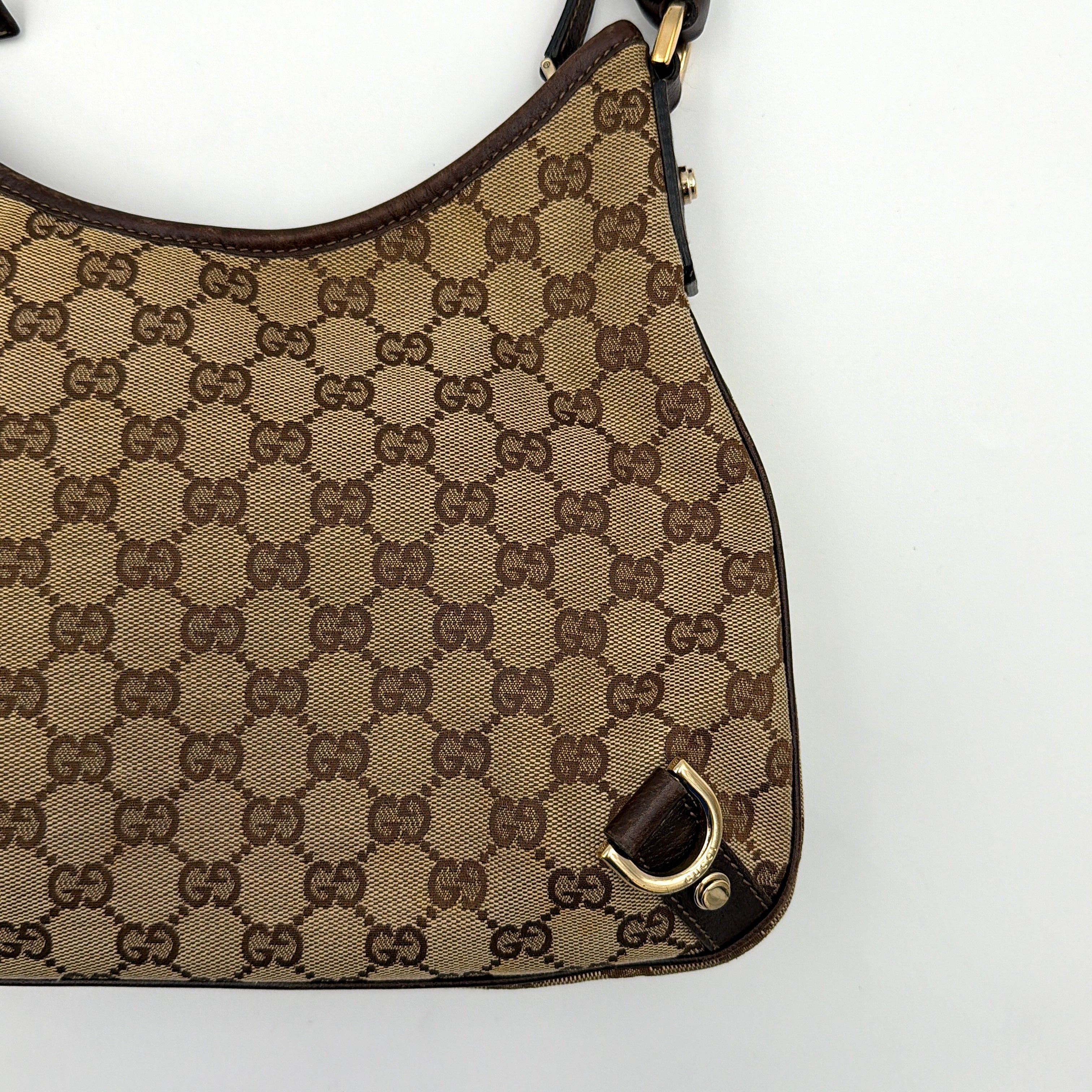 Front view of the Gucci GG Monogram Jacquard Abbey Hobo Bag in beige and brown canvas with gold-tone hardware and dark brown leather trim.