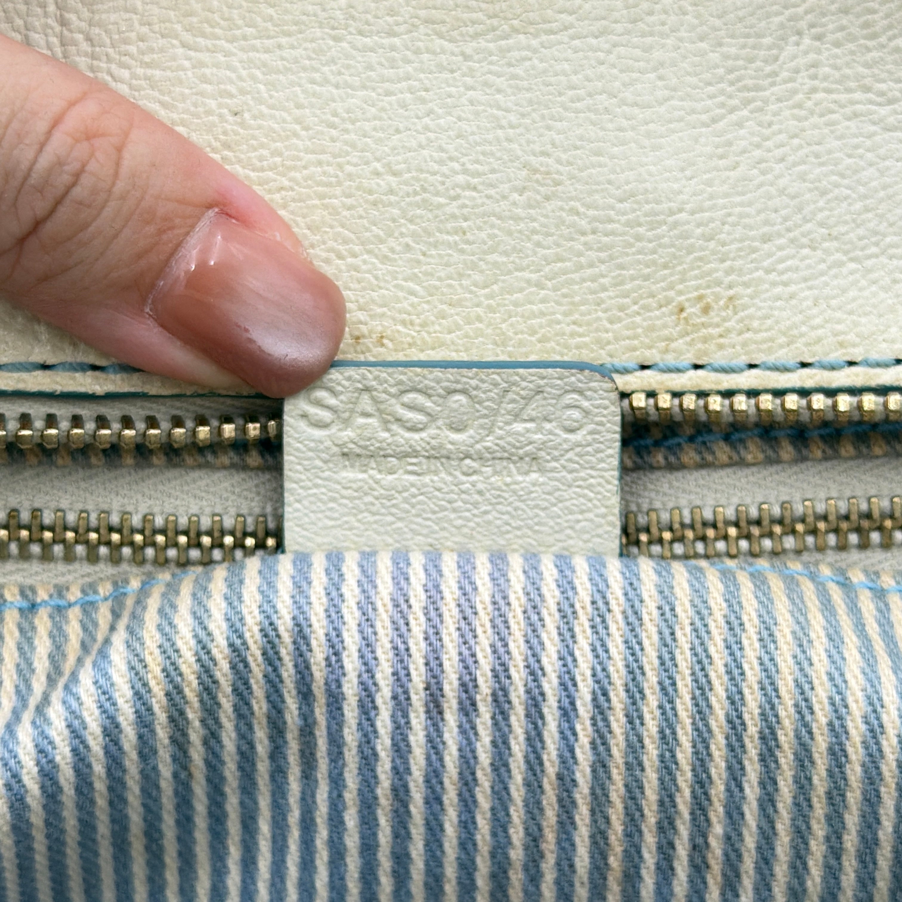 Front view of the Celine Macadam Canvas Shoulder Bag in blue canvas and cream leather with braided handles and gold hardware.