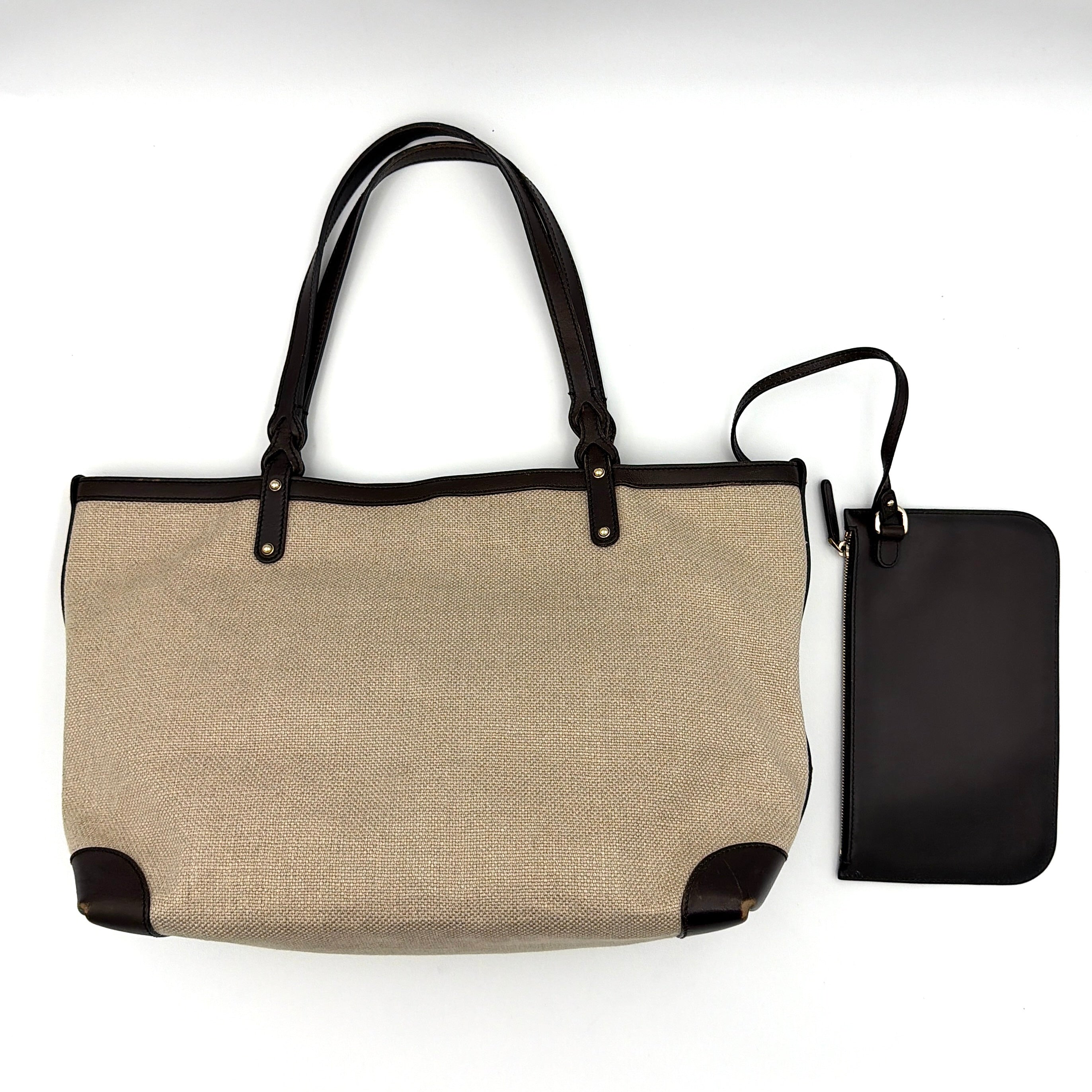 Gucci beige canvas shoulder bag with brown leather trim, bold Gucci logo, and matching detachable leather pouch.