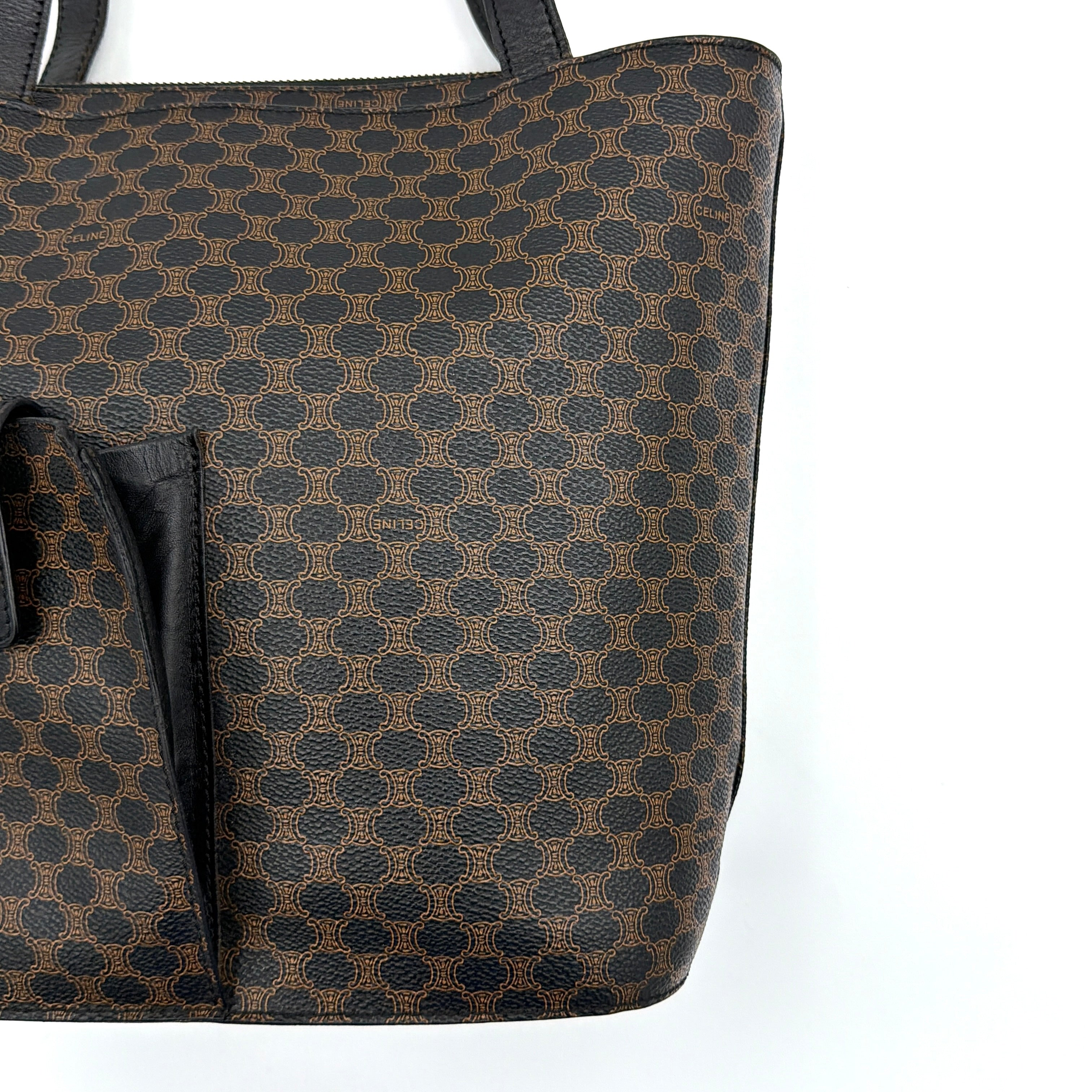 Celine Macadam Blason Tote Bag in brown coated canvas with all-over Macadam motif, black leather trim, and gold-tone Blason emblem front pocket.