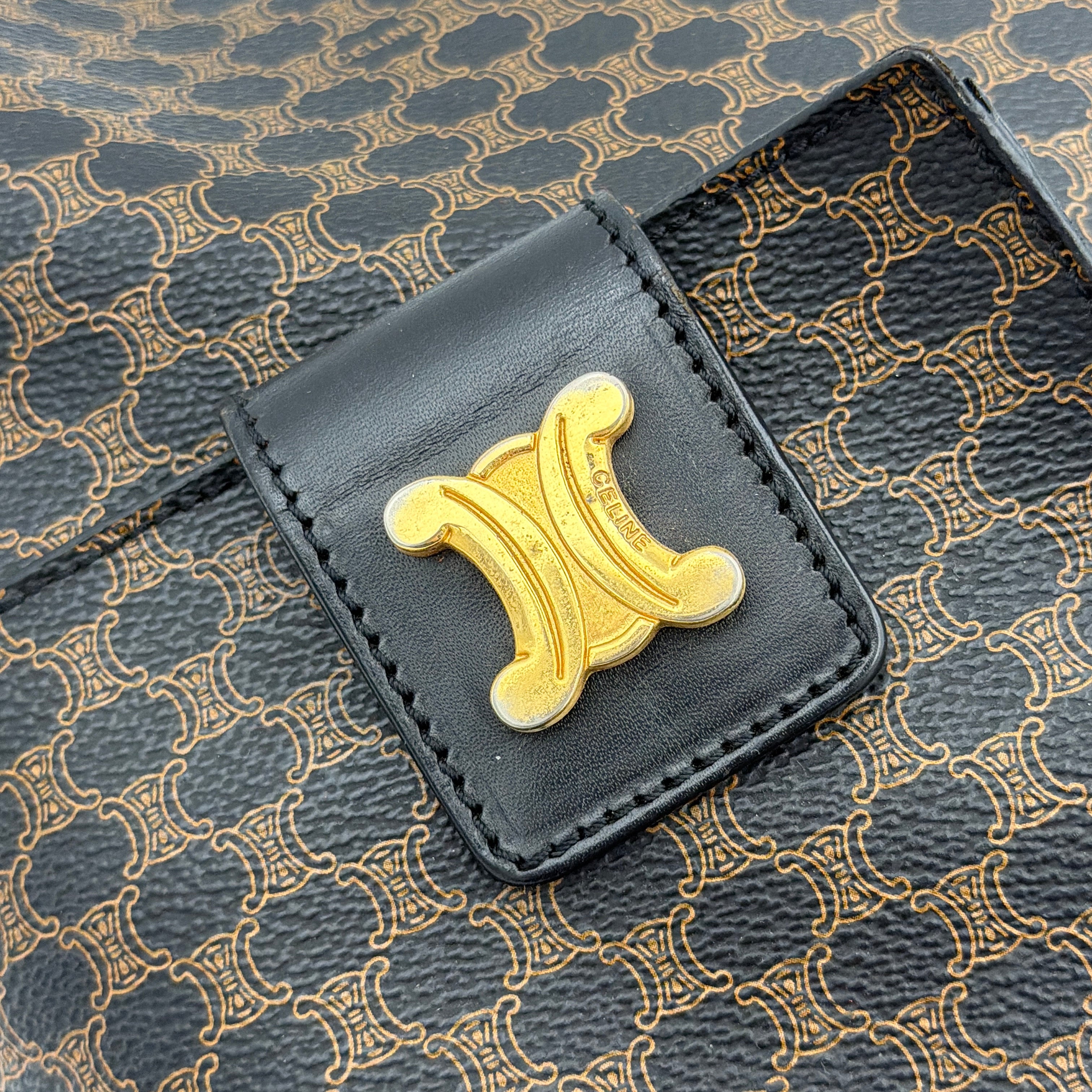 Celine Macadam Blason Tote Bag in brown coated canvas with all-over Macadam motif, black leather trim, and gold-tone Blason emblem front pocket.