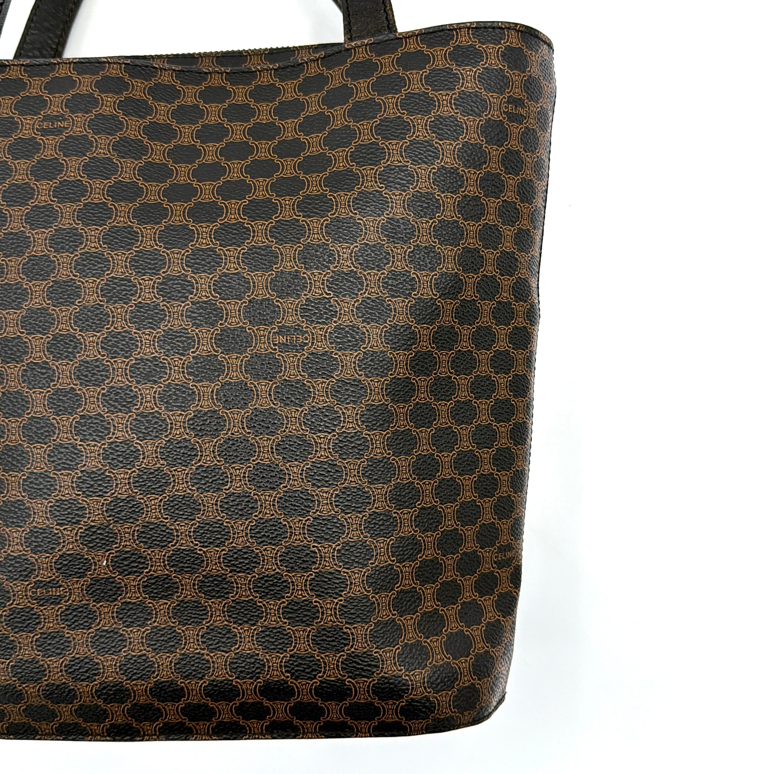 Celine Macadam Blason Tote Bag in brown coated canvas with all-over Macadam motif, black leather trim, and gold-tone Blason emblem front pocket.