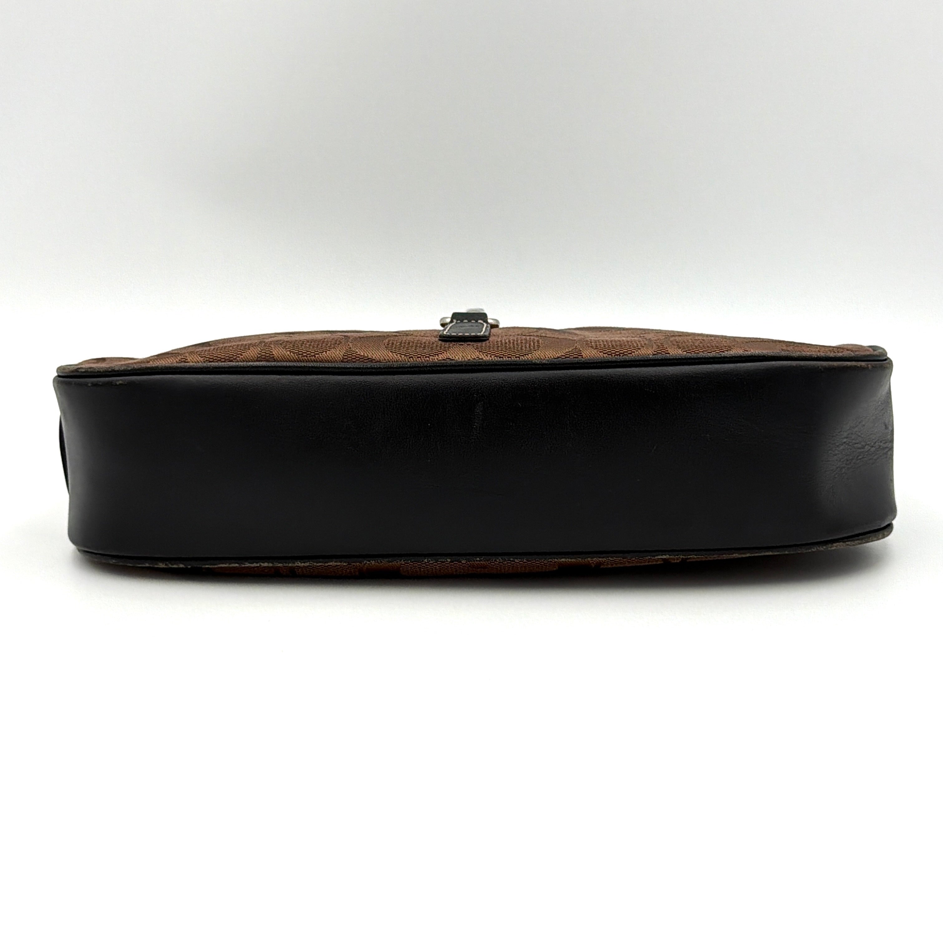 Coach Hobo Signature Clip canvas handbag in brown with black leather trim and silver hardware displayed against a plain background.