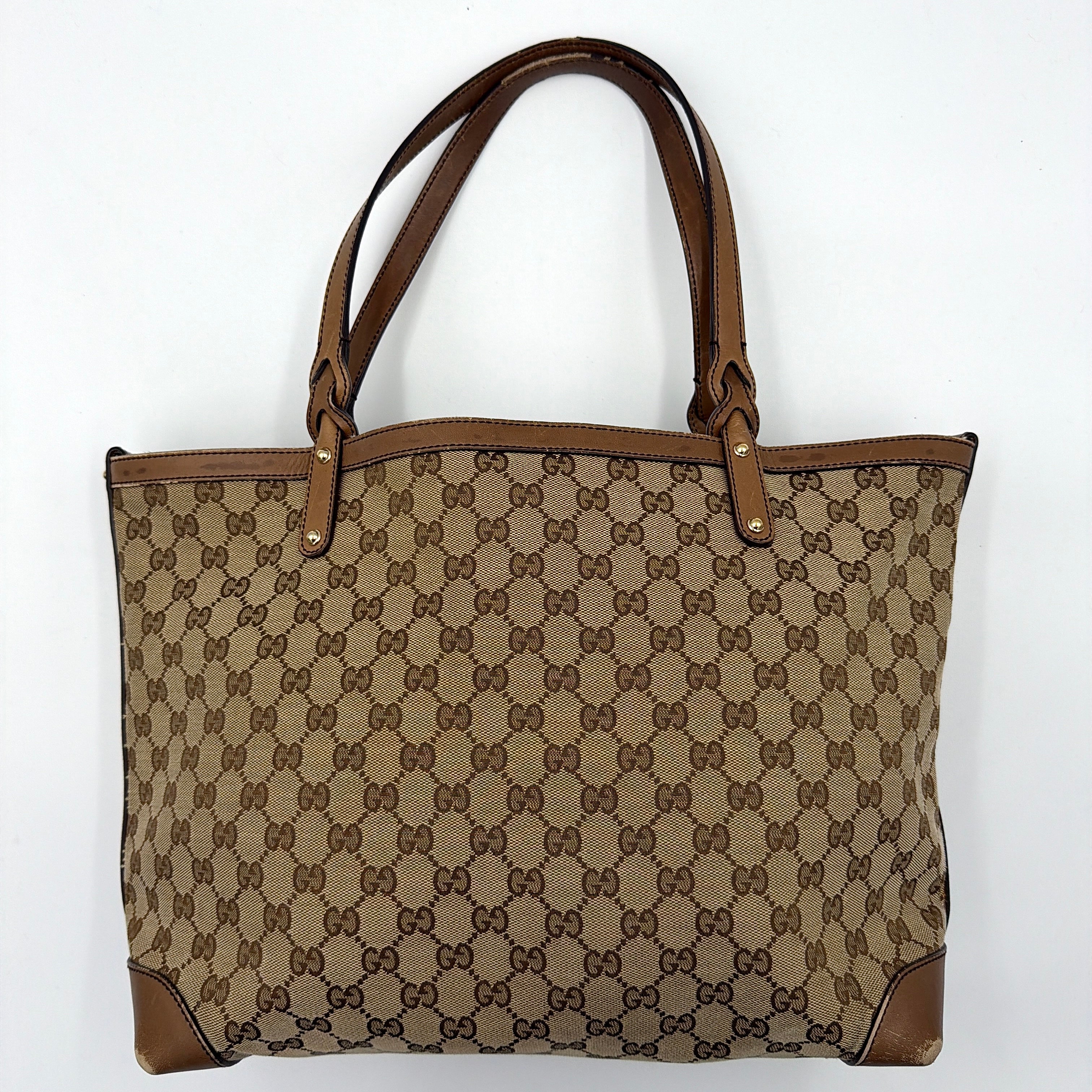 Gucci GG Monogram Craft Shoulder Bag in beige and brown canvas with double leather straps and matching logo-embossed leather pouch.