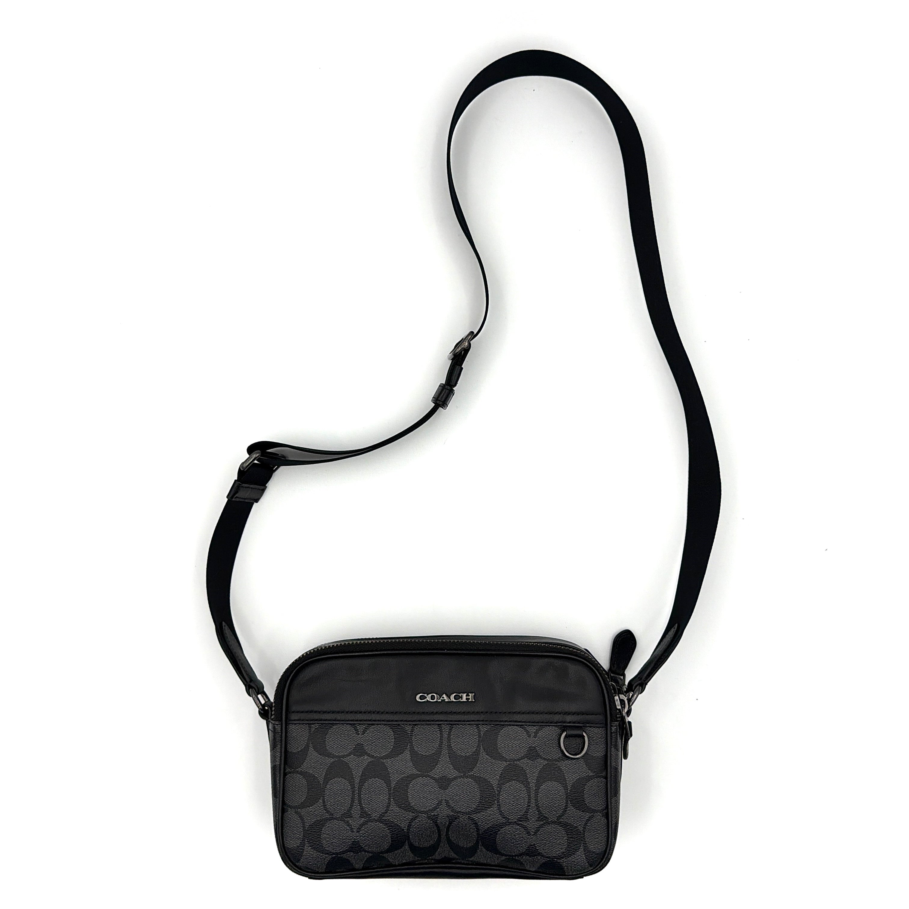 Coach Signature Graham Crossbody Bag in grey and black with adjustable web strap and silver-tone hardware, presented against a white background.