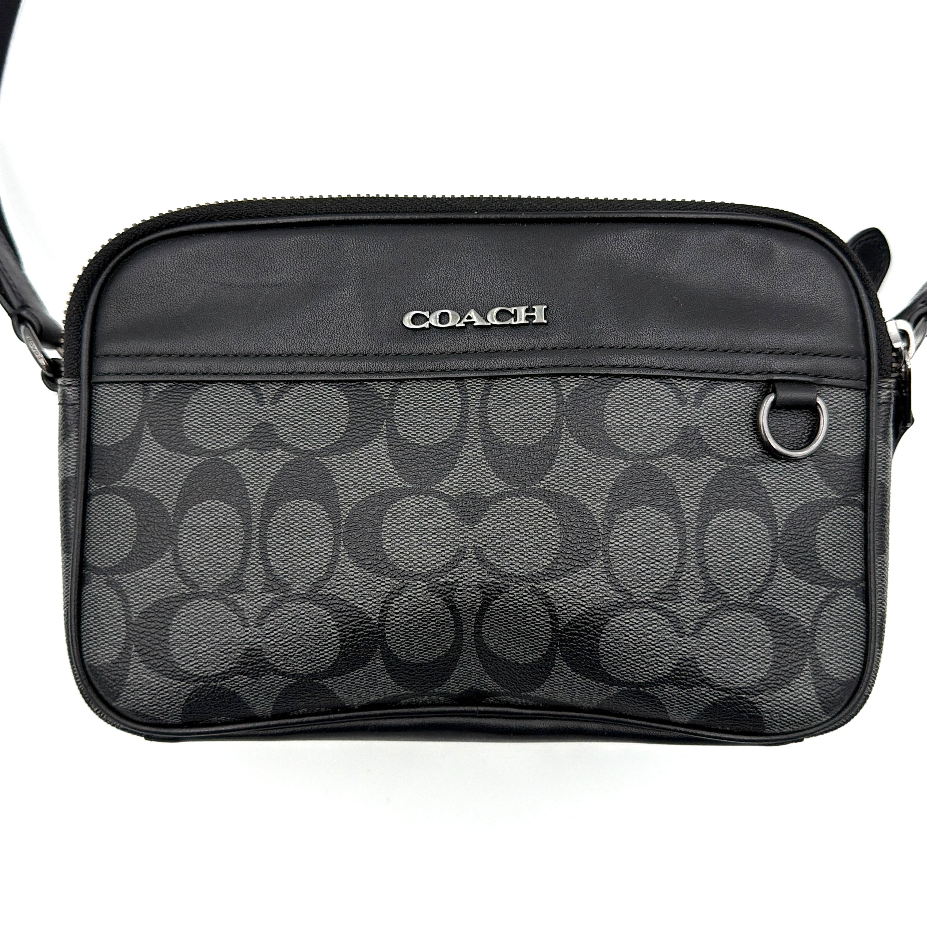 Coach Signature Graham Crossbody Bag in grey and black with adjustable web strap and silver-tone hardware, presented against a white background.