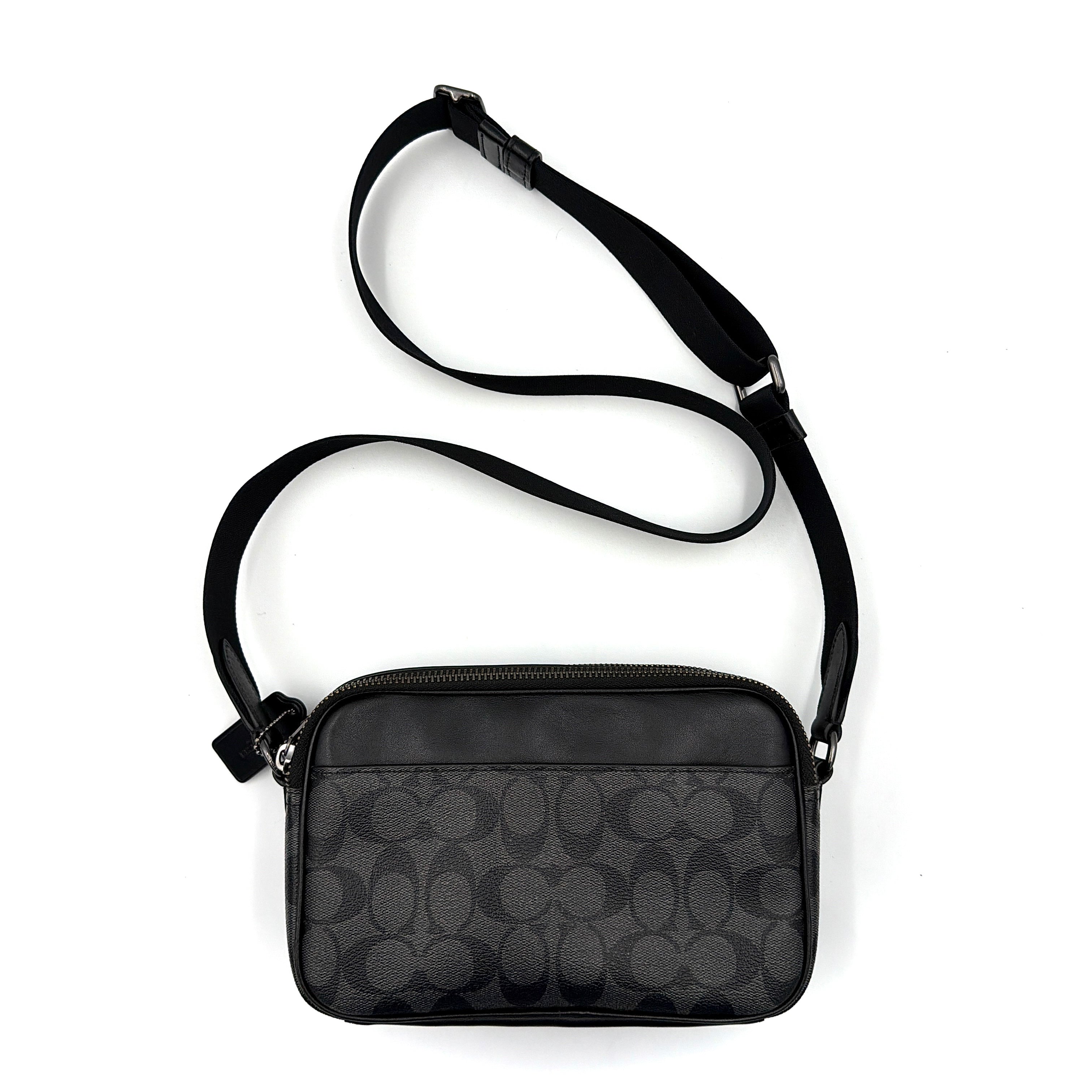 Coach Signature Graham Crossbody Bag in grey and black with adjustable web strap and silver-tone hardware, presented against a white background.