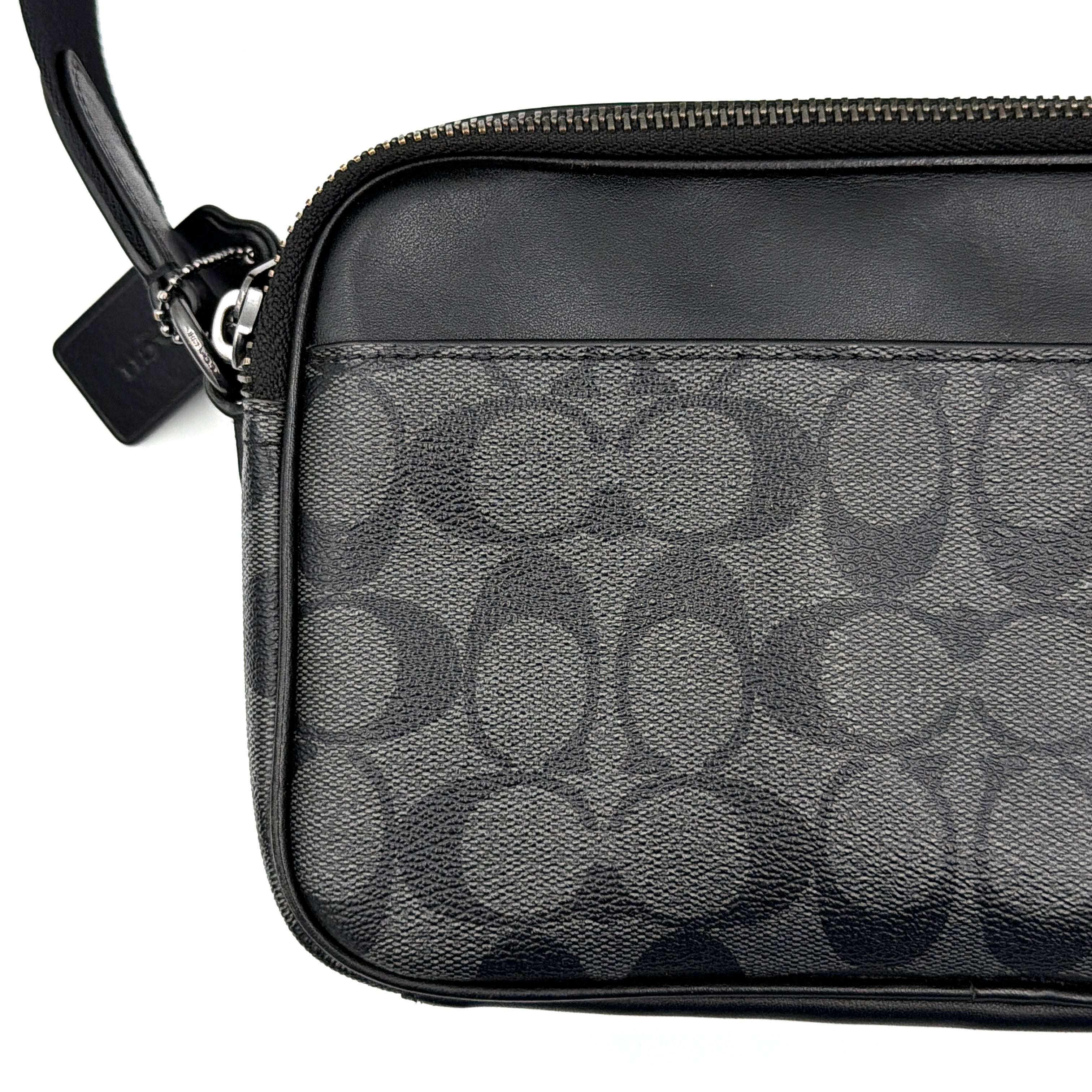 Coach Signature Graham Crossbody Bag in grey and black with adjustable web strap and silver-tone hardware, presented against a white background.