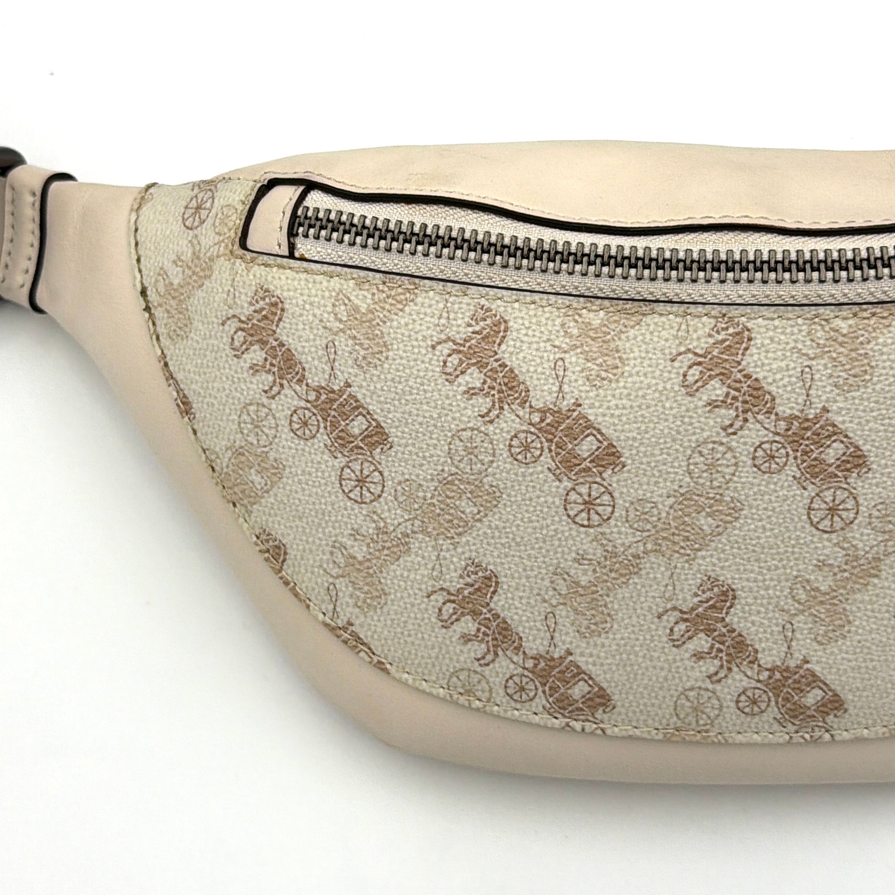 Coach Mini Warren belt bag in cream canvas with tan horse and carriage motif, leather trim, and black adjustable strap.