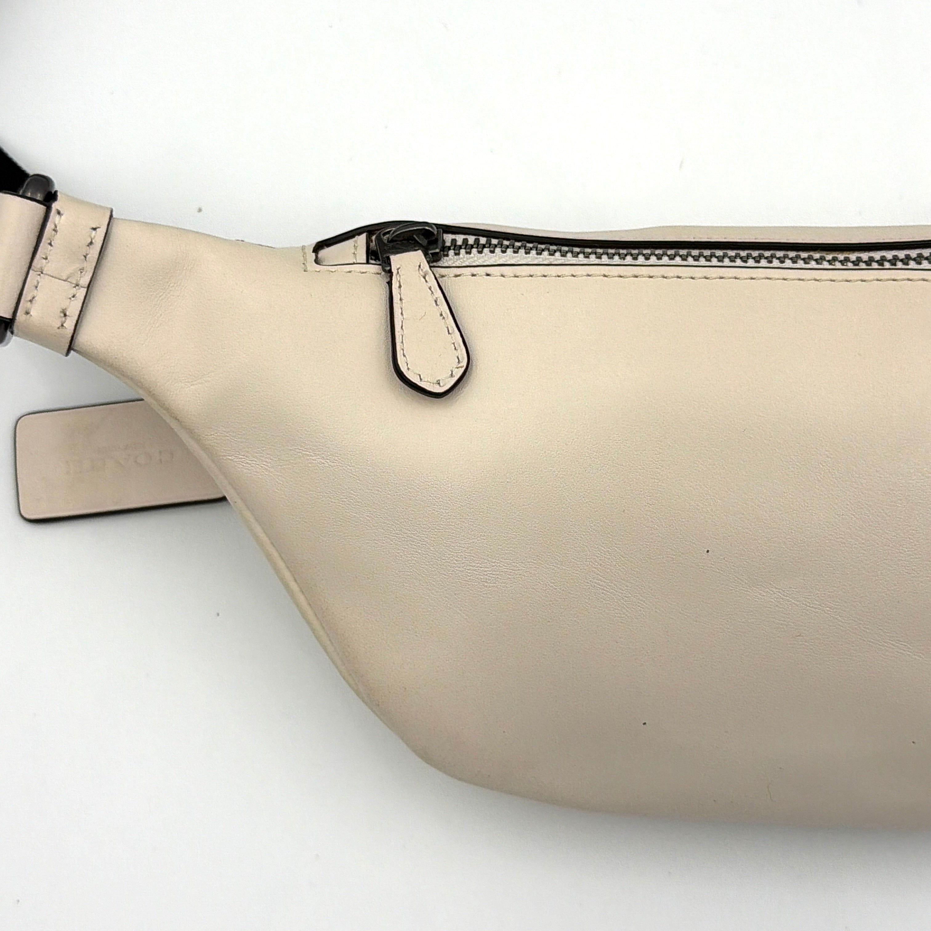 Coach Mini Warren belt bag in cream canvas with tan horse and carriage motif, leather trim, and black adjustable strap.