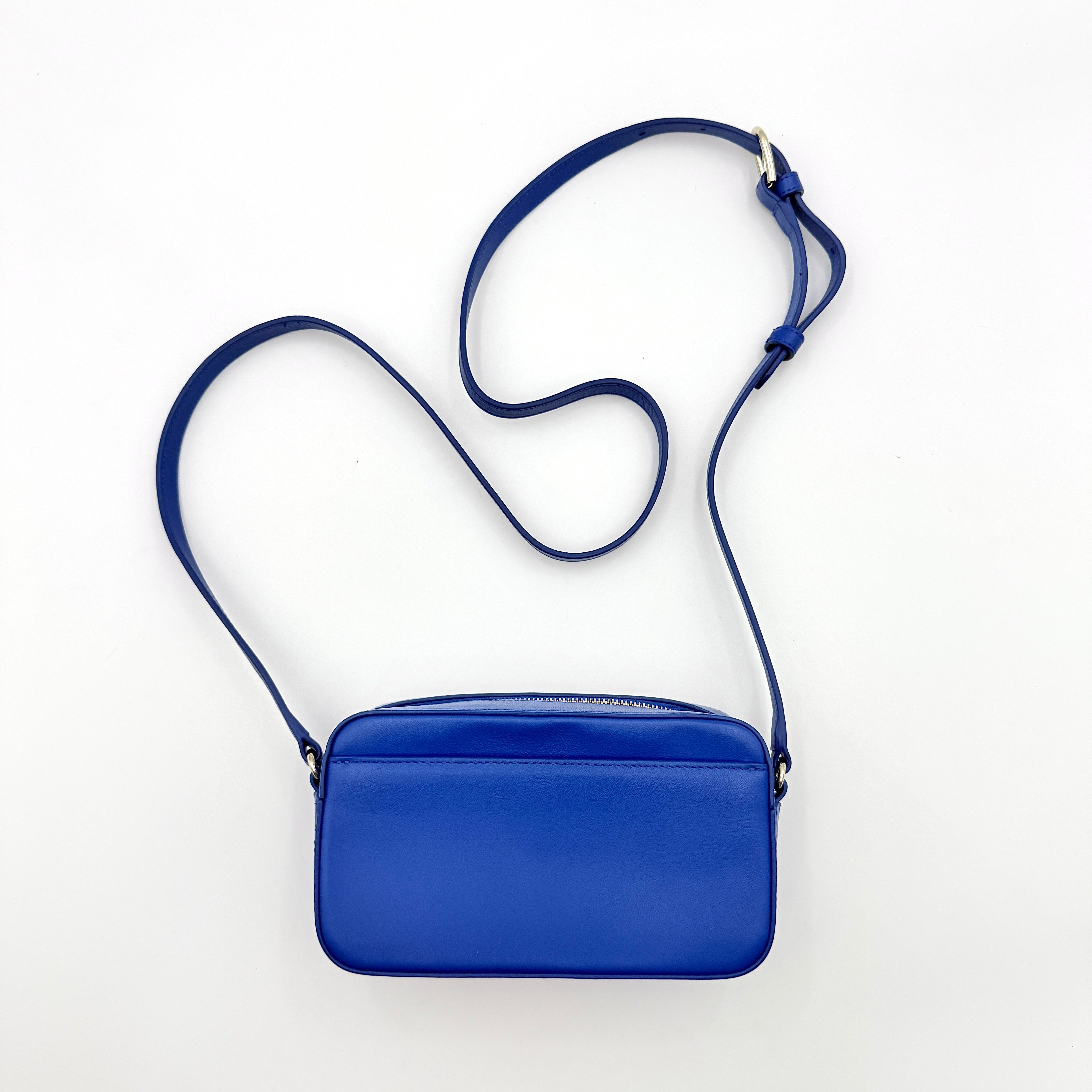 Furla Primula Mini Camera Crossbody Bag in vibrant blue leather with embossed logo, shown with adjustable strap.