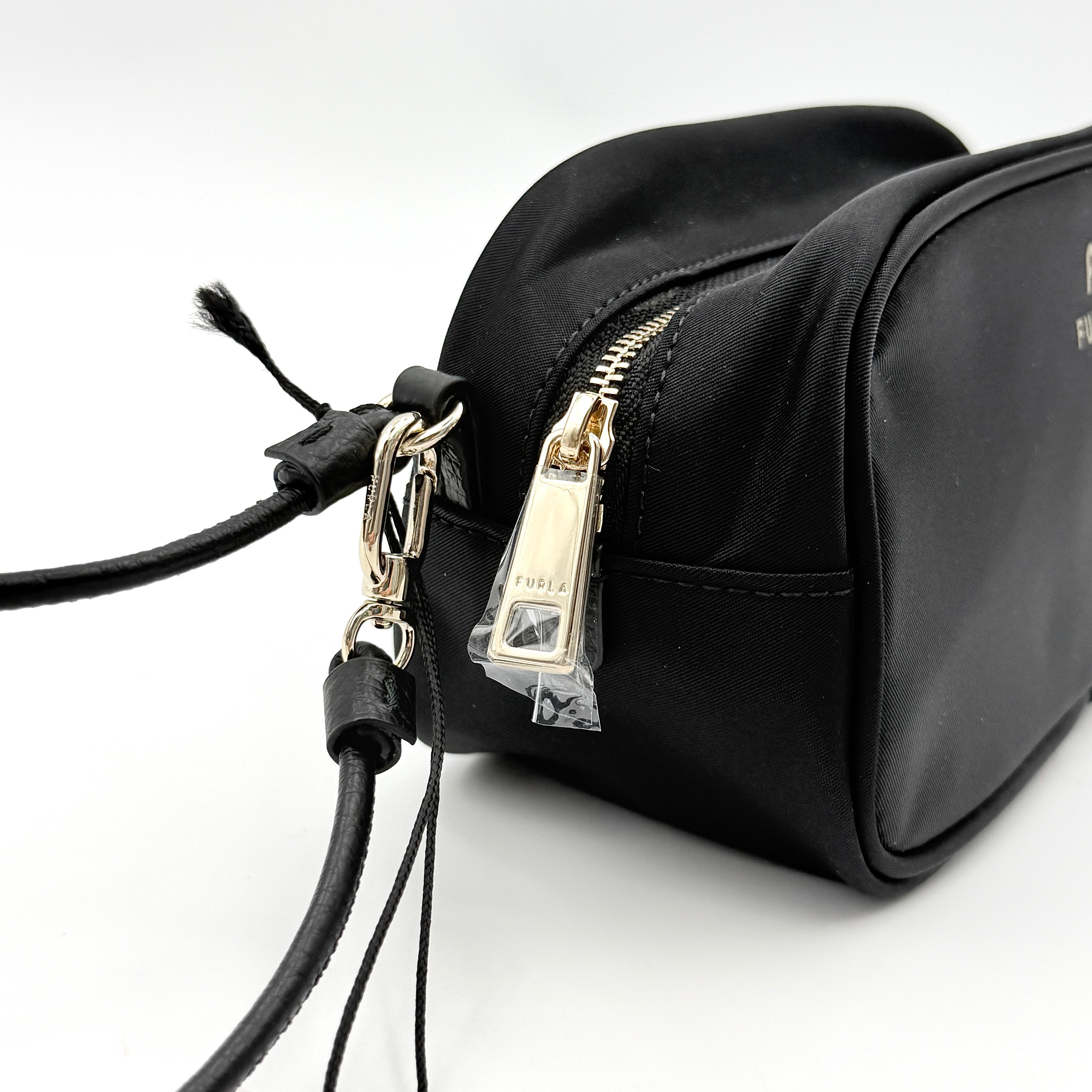 Furla Camelia Cosmetic Case in black nylon with gold logo and wristlet strap, shown with original tag.