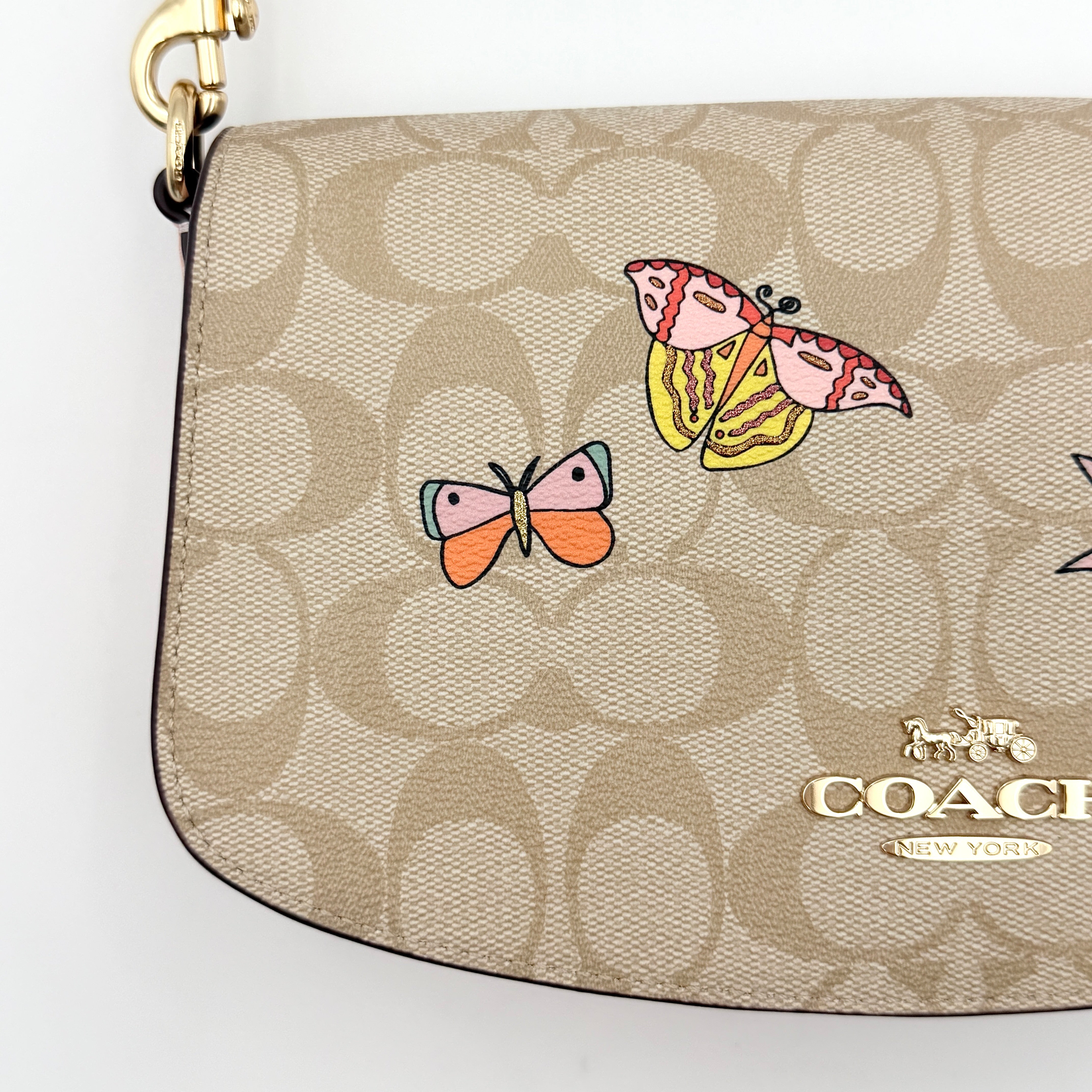 Coach X Observed By Us Andrea Shoulder Bag in beige monogram canvas with pink illustrations and pink leather strap.