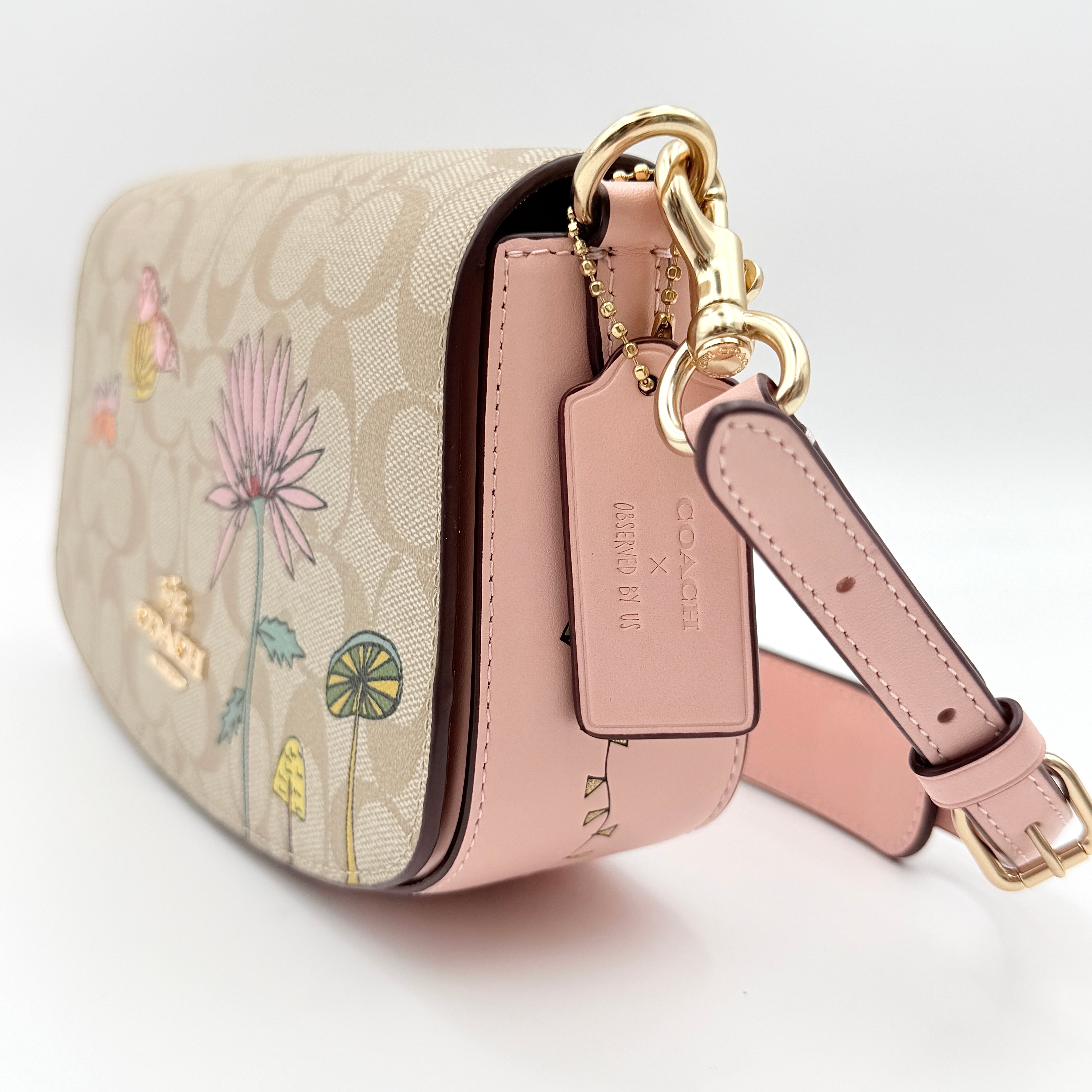 Coach X Observed By Us Andrea Shoulder Bag in beige monogram canvas with pink illustrations and pink leather strap.