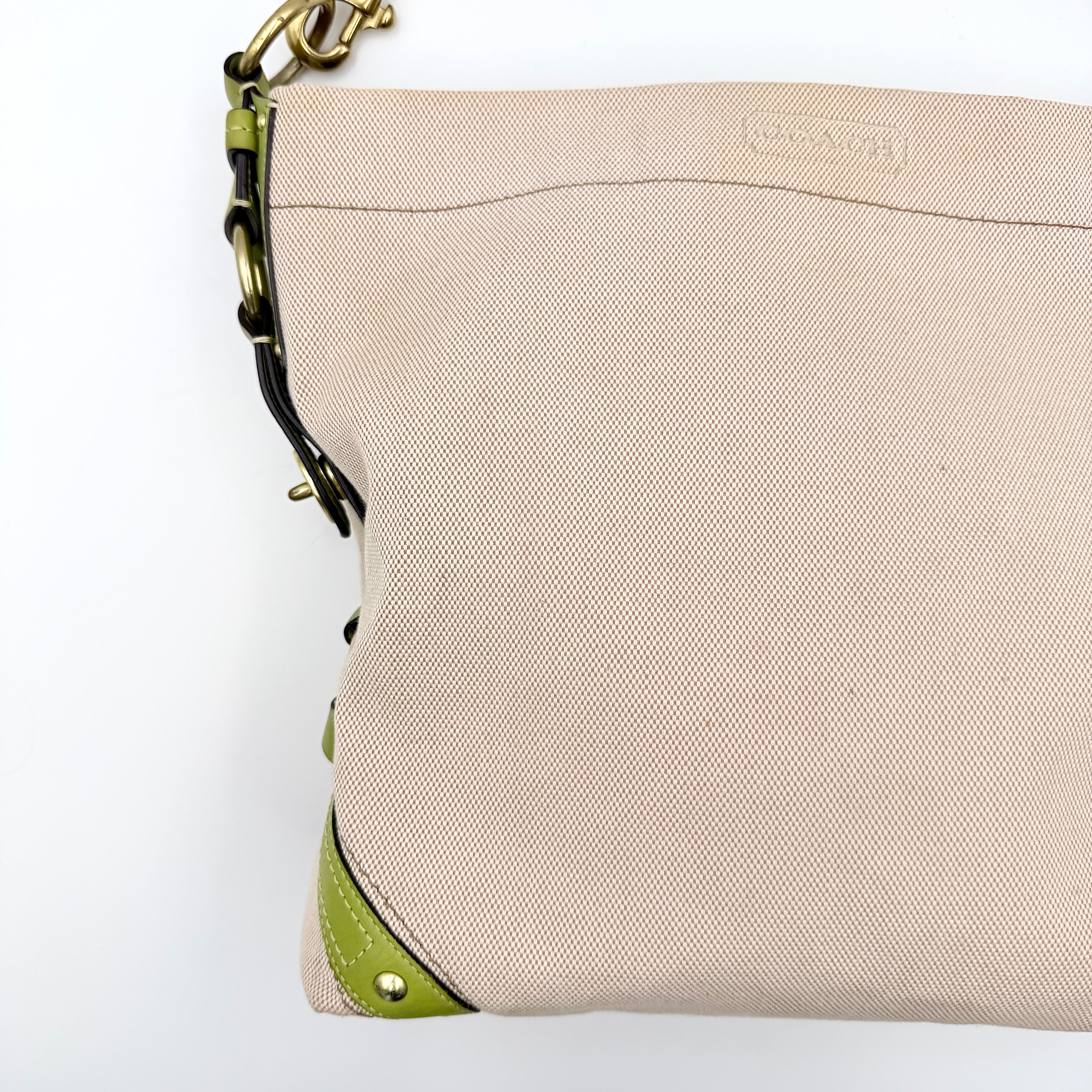 Coach Carly Hobo Shoulder Bag in beige canvas with green leather trim and gold hardware, shown on a white background.