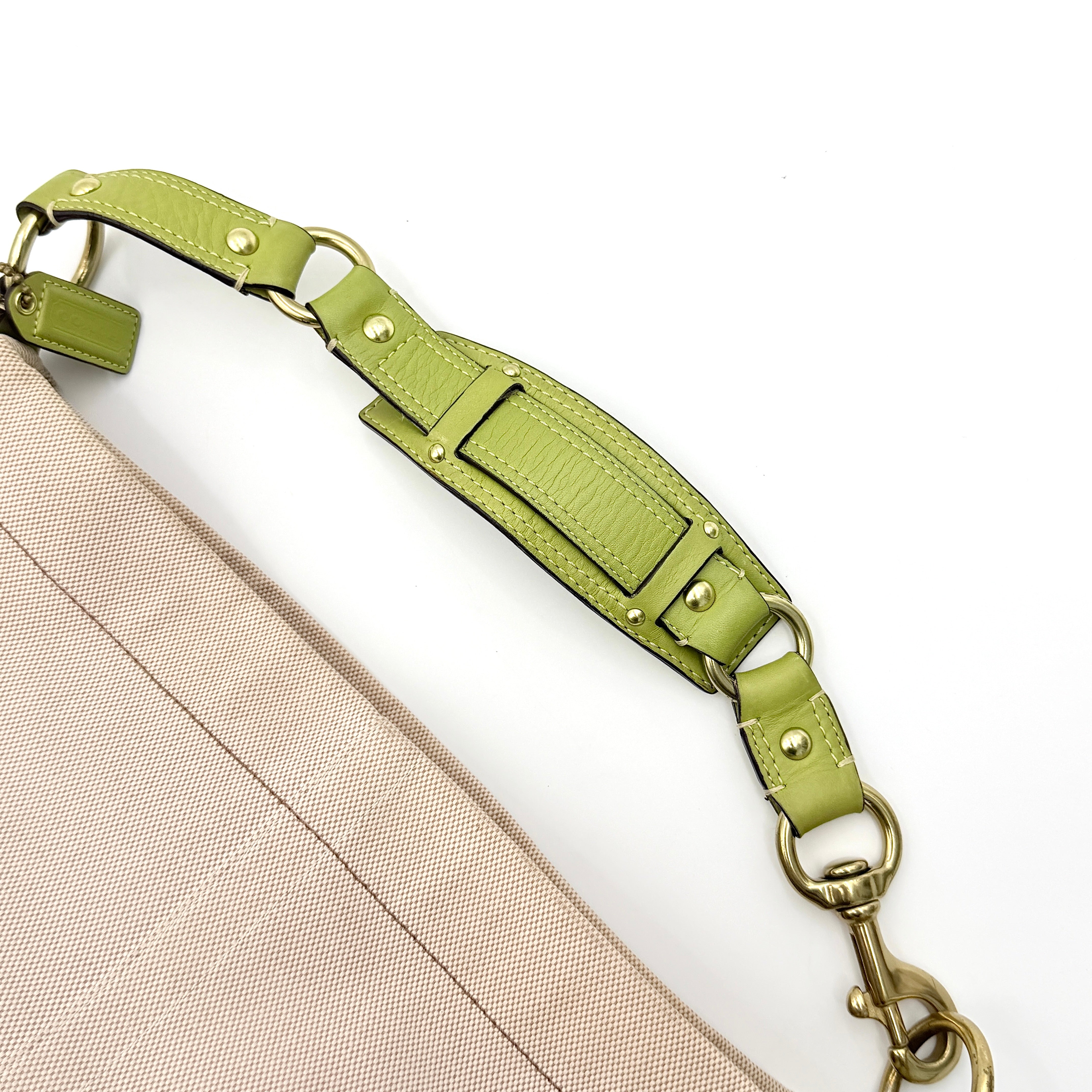 Coach Carly Hobo Shoulder Bag in beige canvas with green leather trim and gold hardware, shown on a white background.