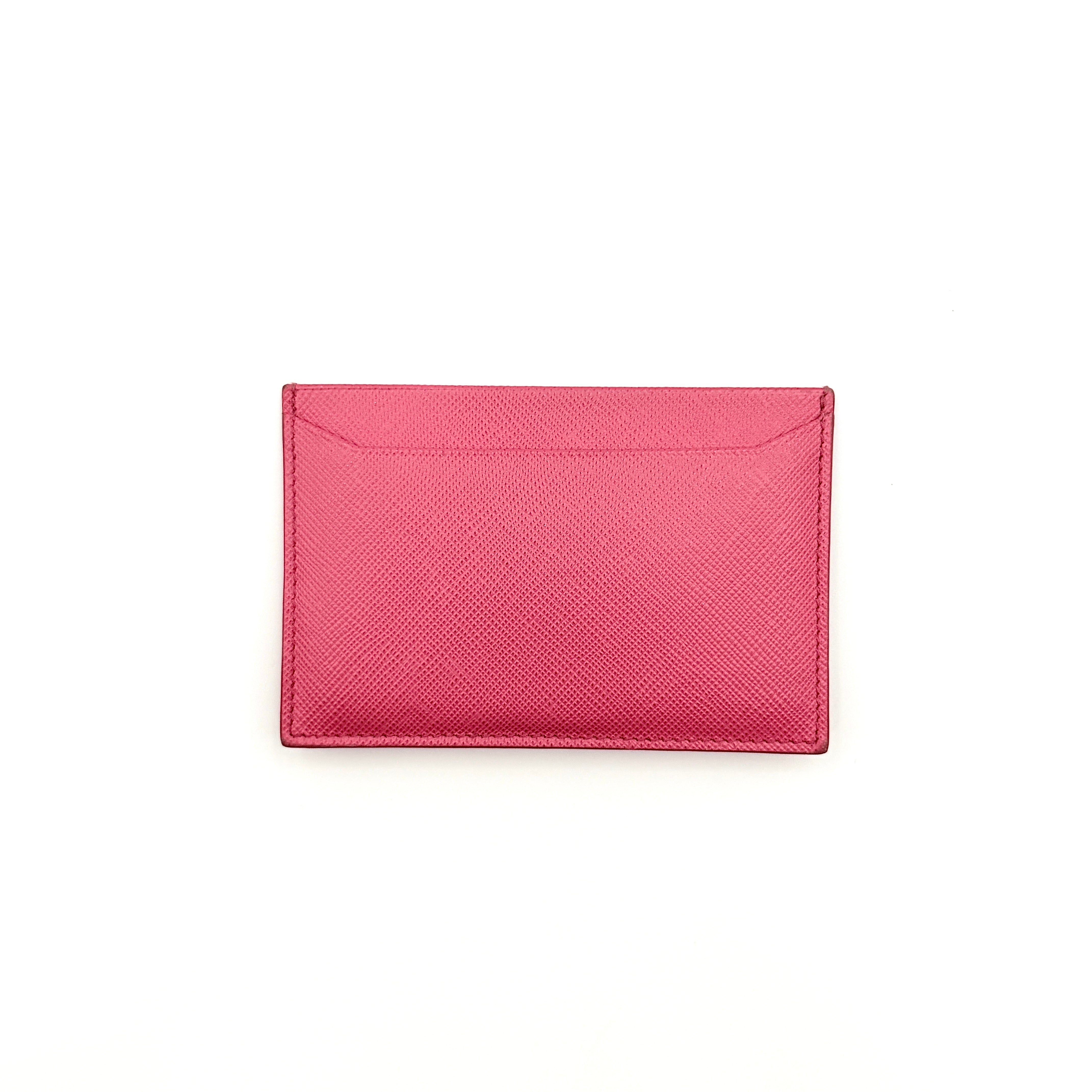 Prada Saffiano card holder in pink leather with gold-tone triangle logo plaque on the front.