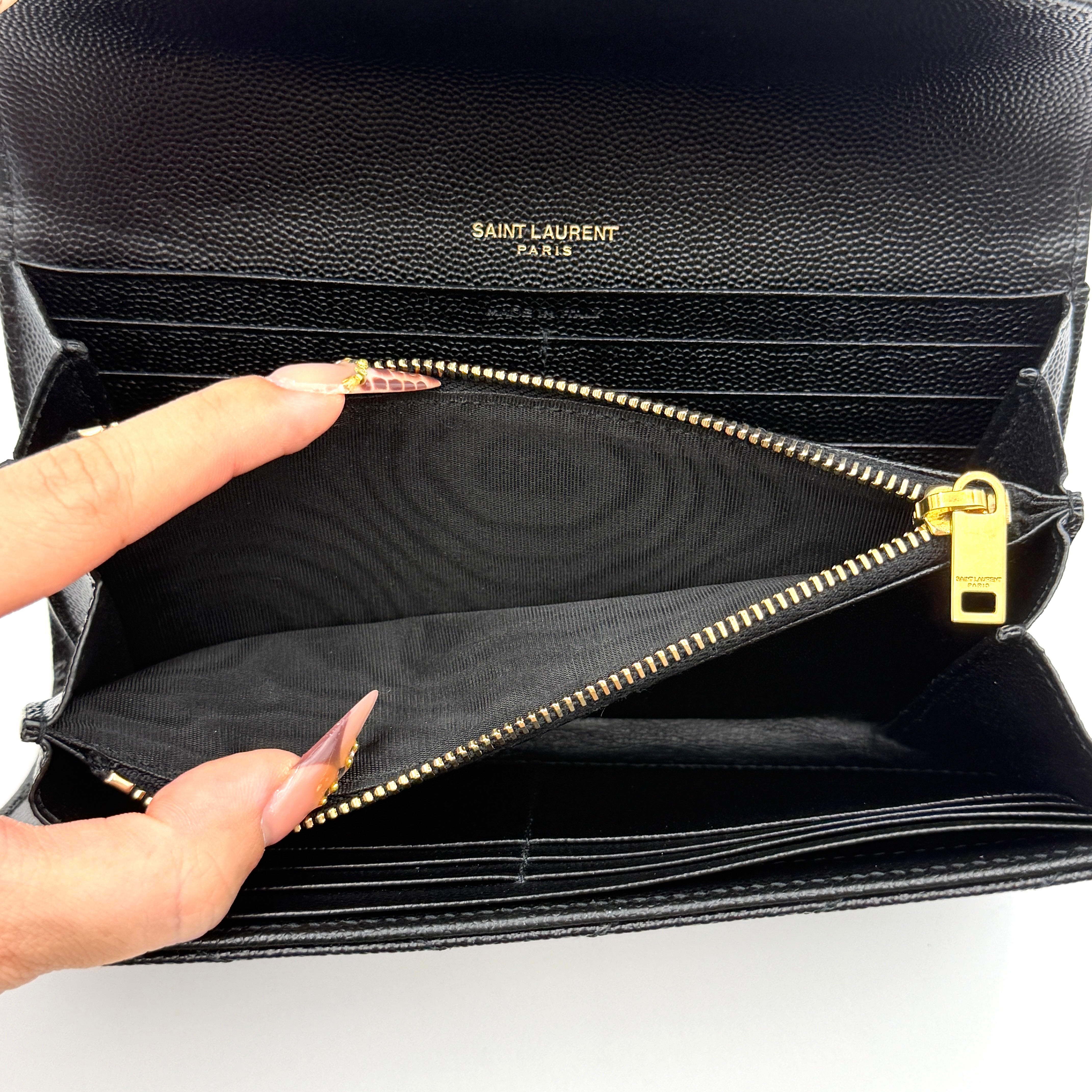 Saint Laurent Cassandre Large Flap Wallet in black grained leather with gold YSL monogram and chevron quilting.