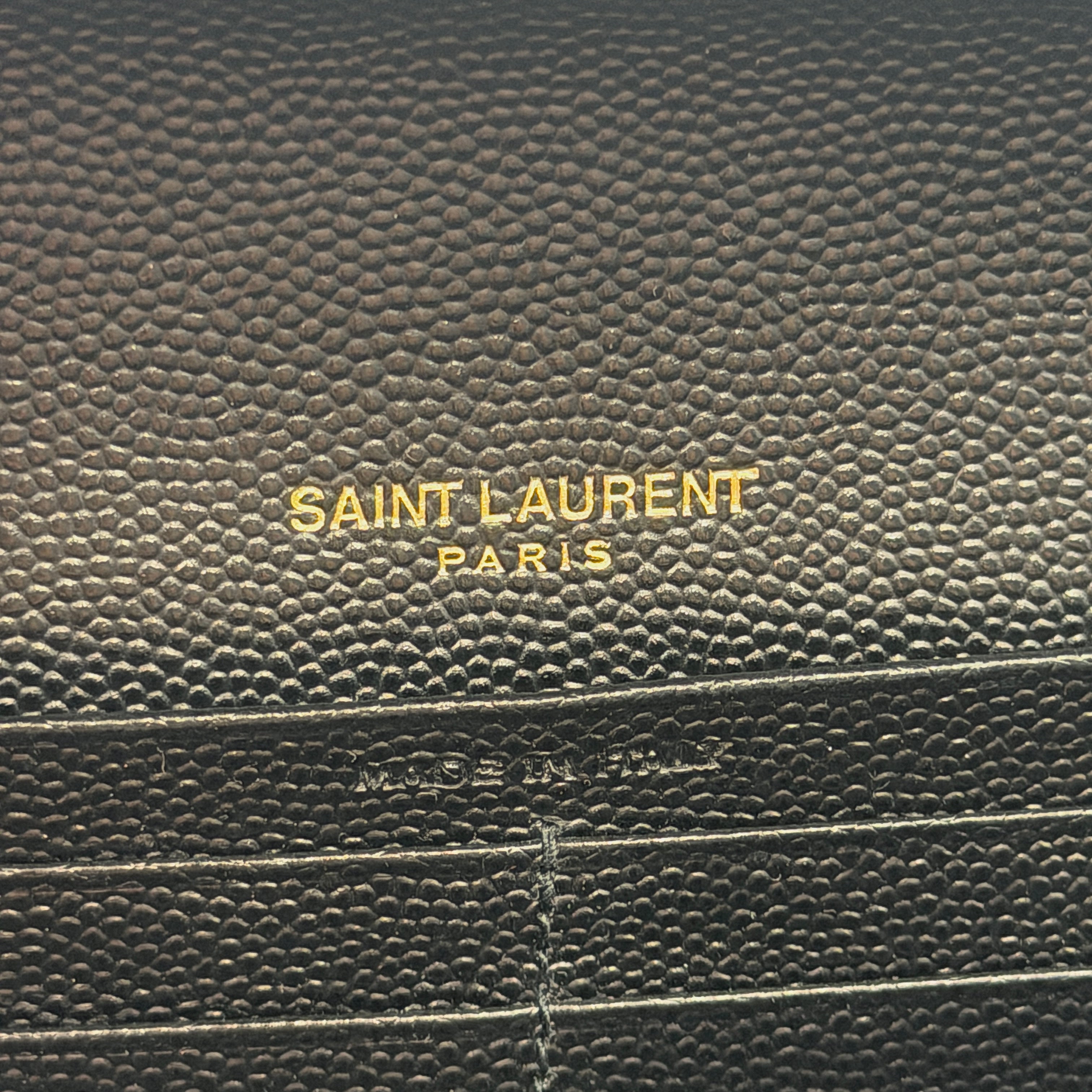 Saint Laurent Cassandre Large Flap Wallet in black grained leather with gold YSL monogram and chevron quilting.