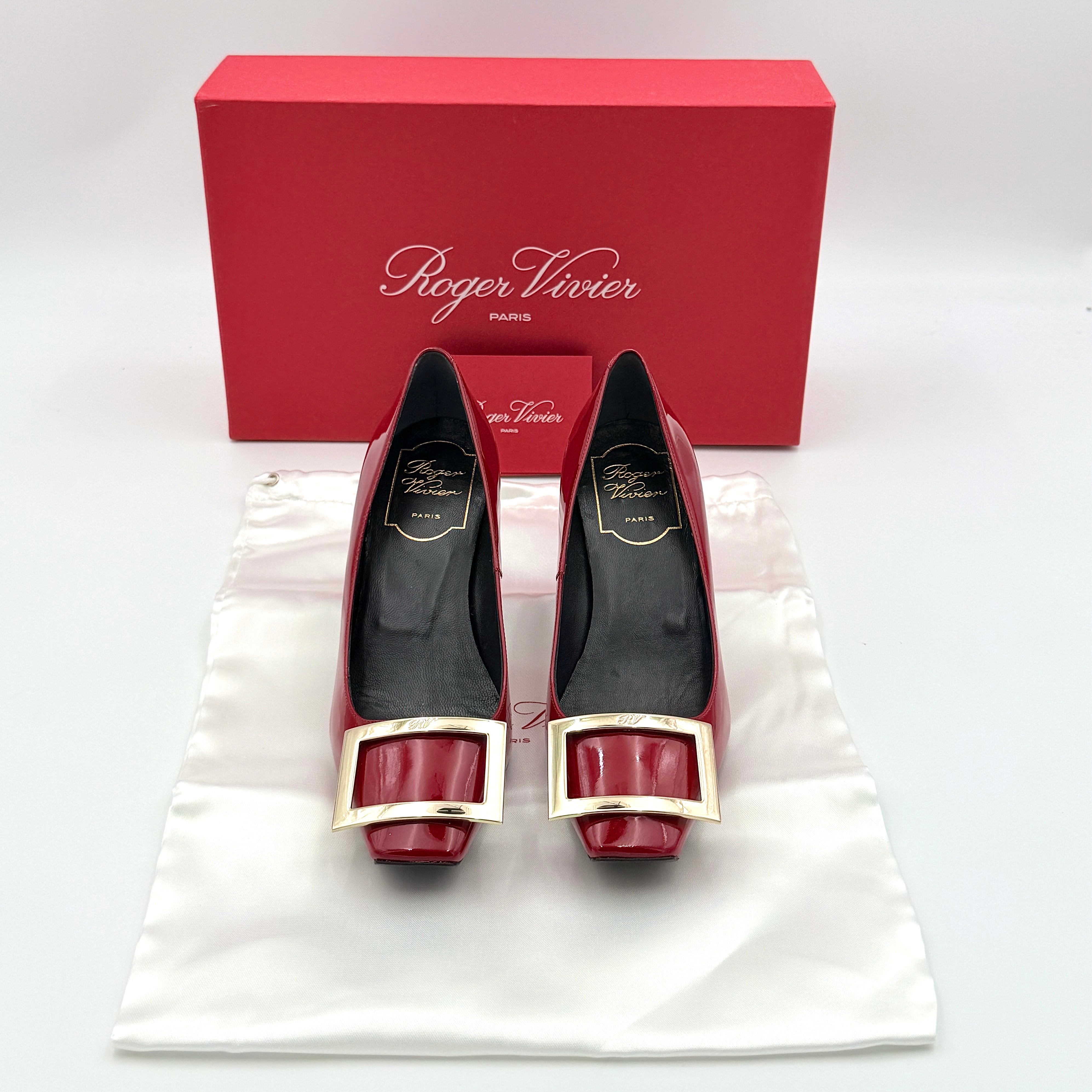 Pair of Roger Vivier Belle Vivier Trompette patent pumps in glossy red with gold-tone buckles, exuding a polished finish.