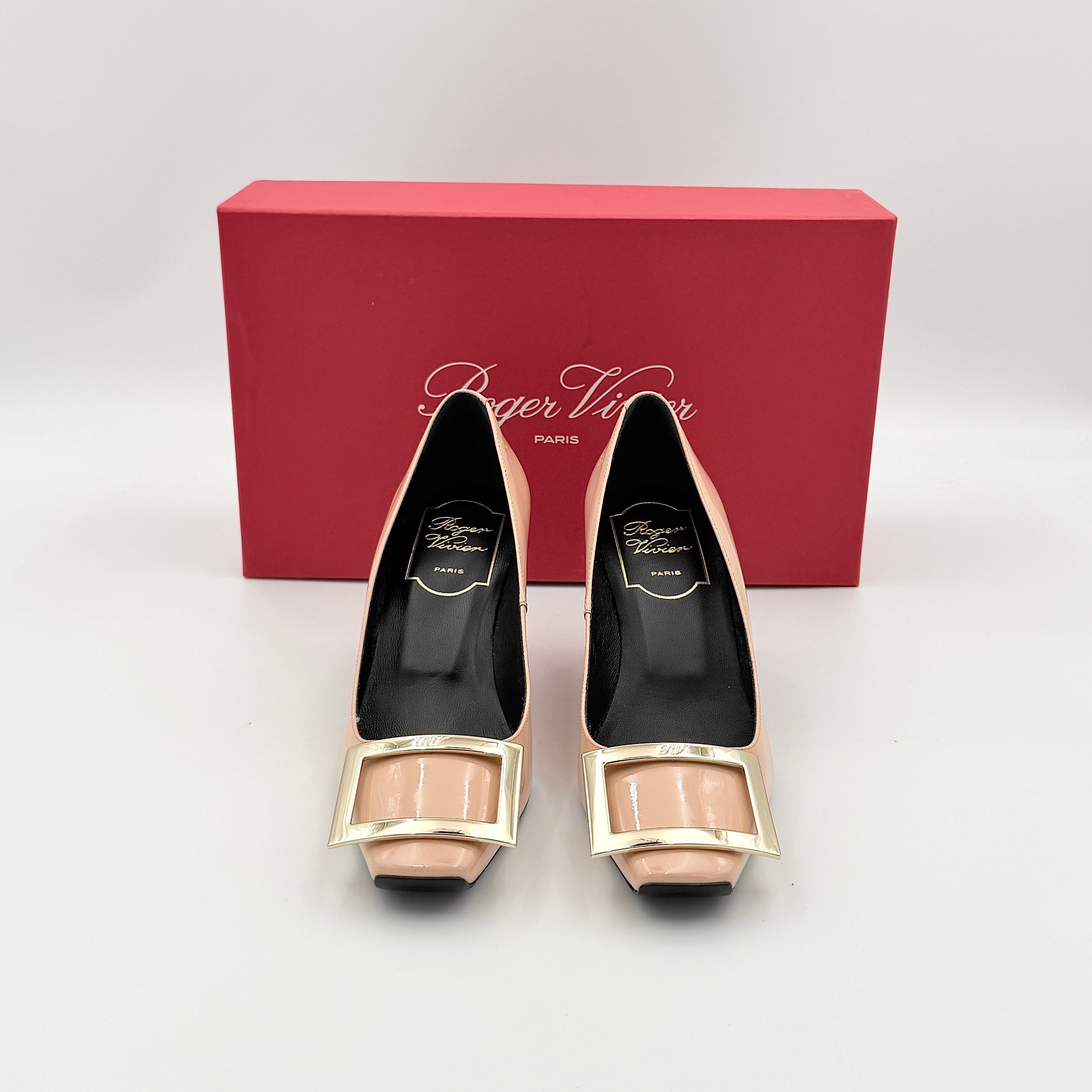 A pair of Roger Vivier Belle Vivier Trompette pumps in patent blush pink leather with signature gold buckles at the toe.