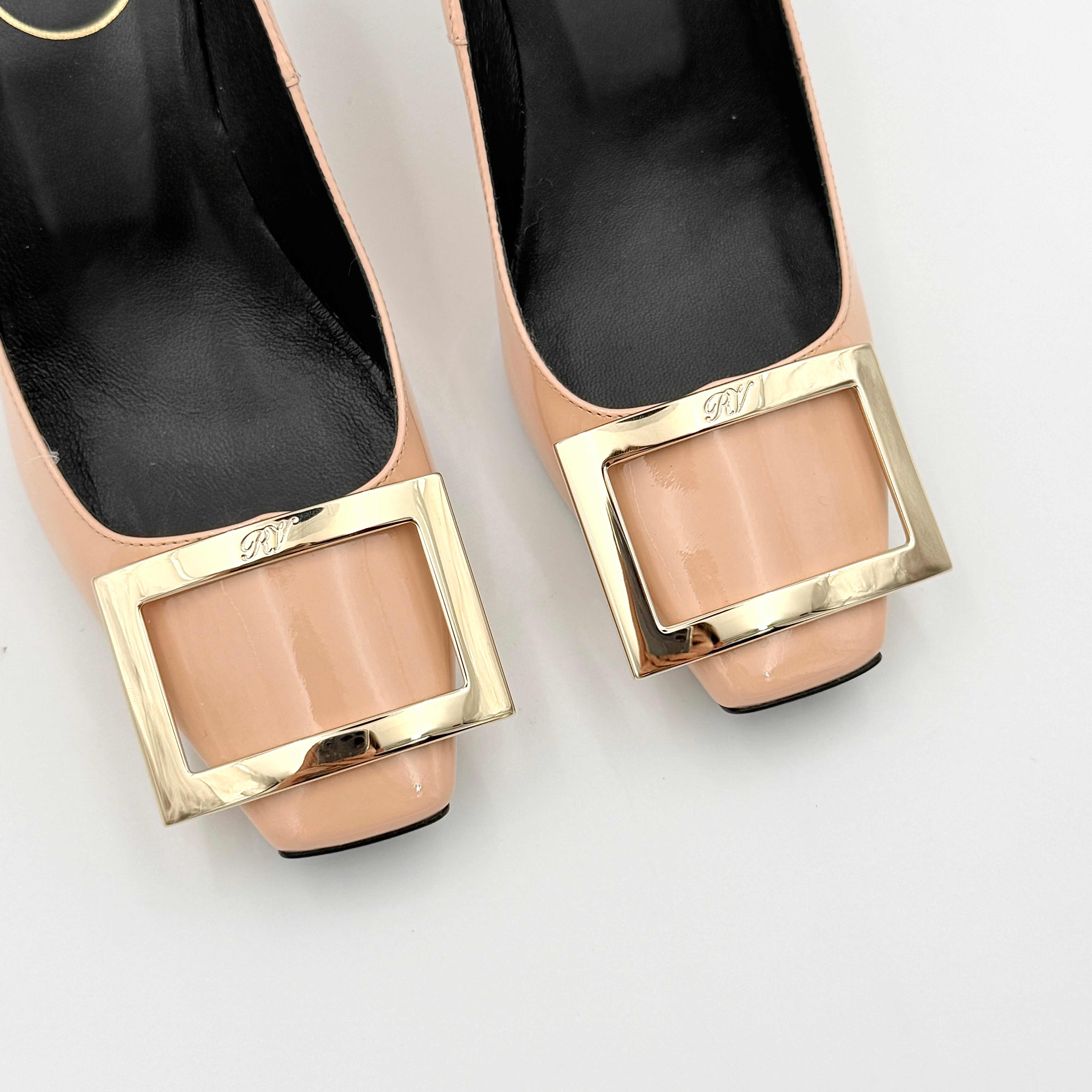 A pair of Roger Vivier Belle Vivier Trompette pumps in patent blush pink leather with signature gold buckles at the toe.