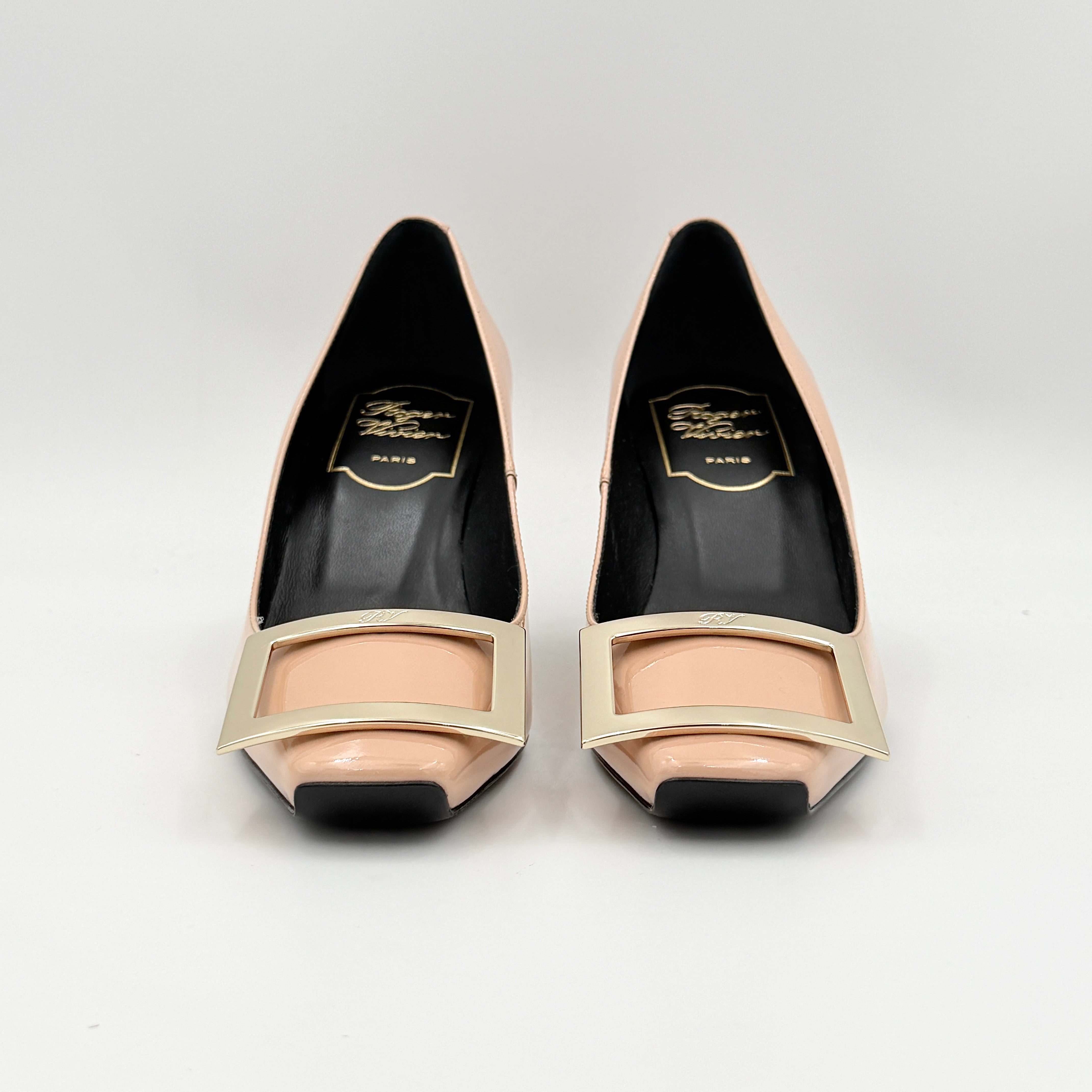 A pair of Roger Vivier Belle Vivier Trompette pumps in patent blush pink leather with signature gold buckles at the toe.