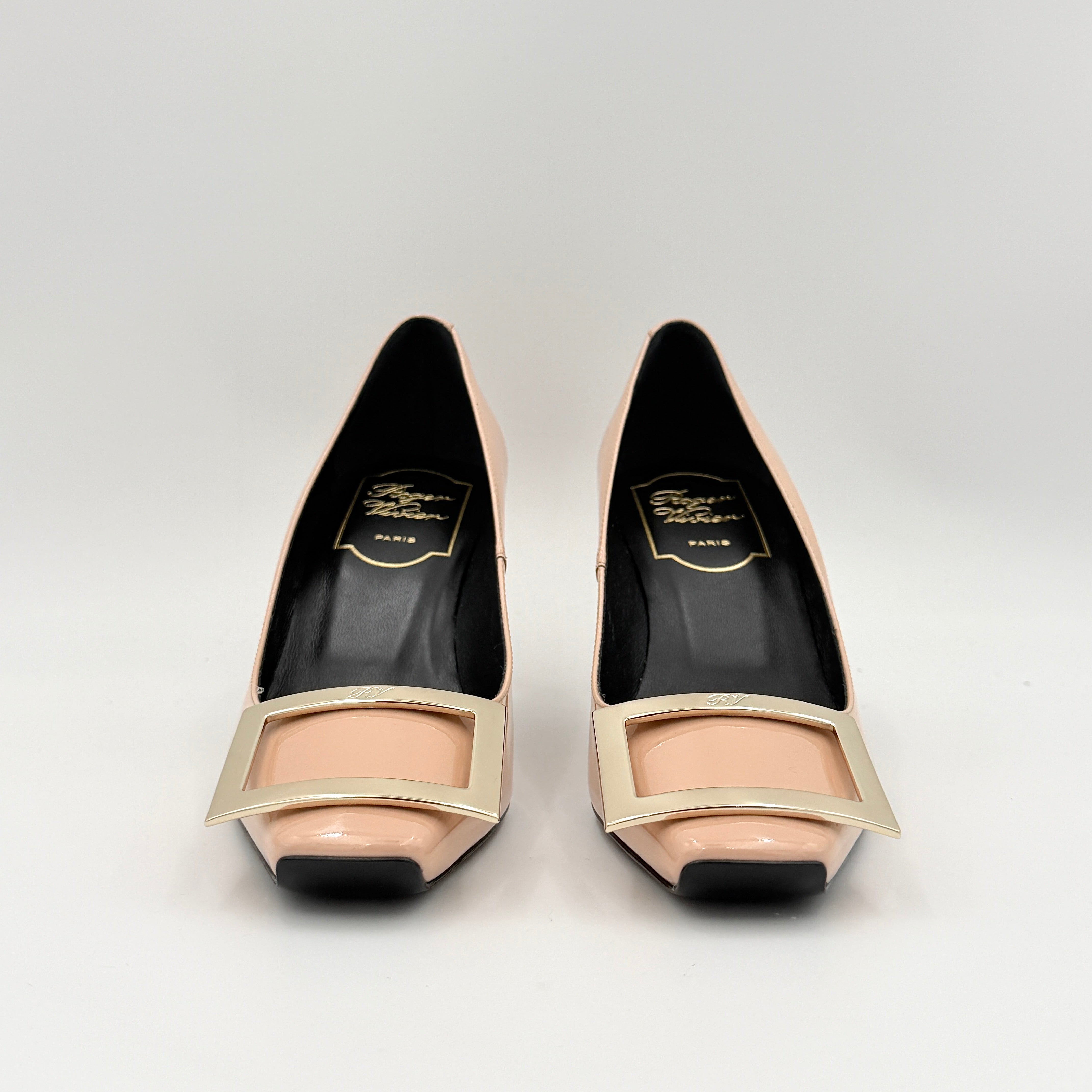 A pair of Roger Vivier Belle Vivier Trompette pumps in patent blush pink leather with signature gold buckles at the toe.