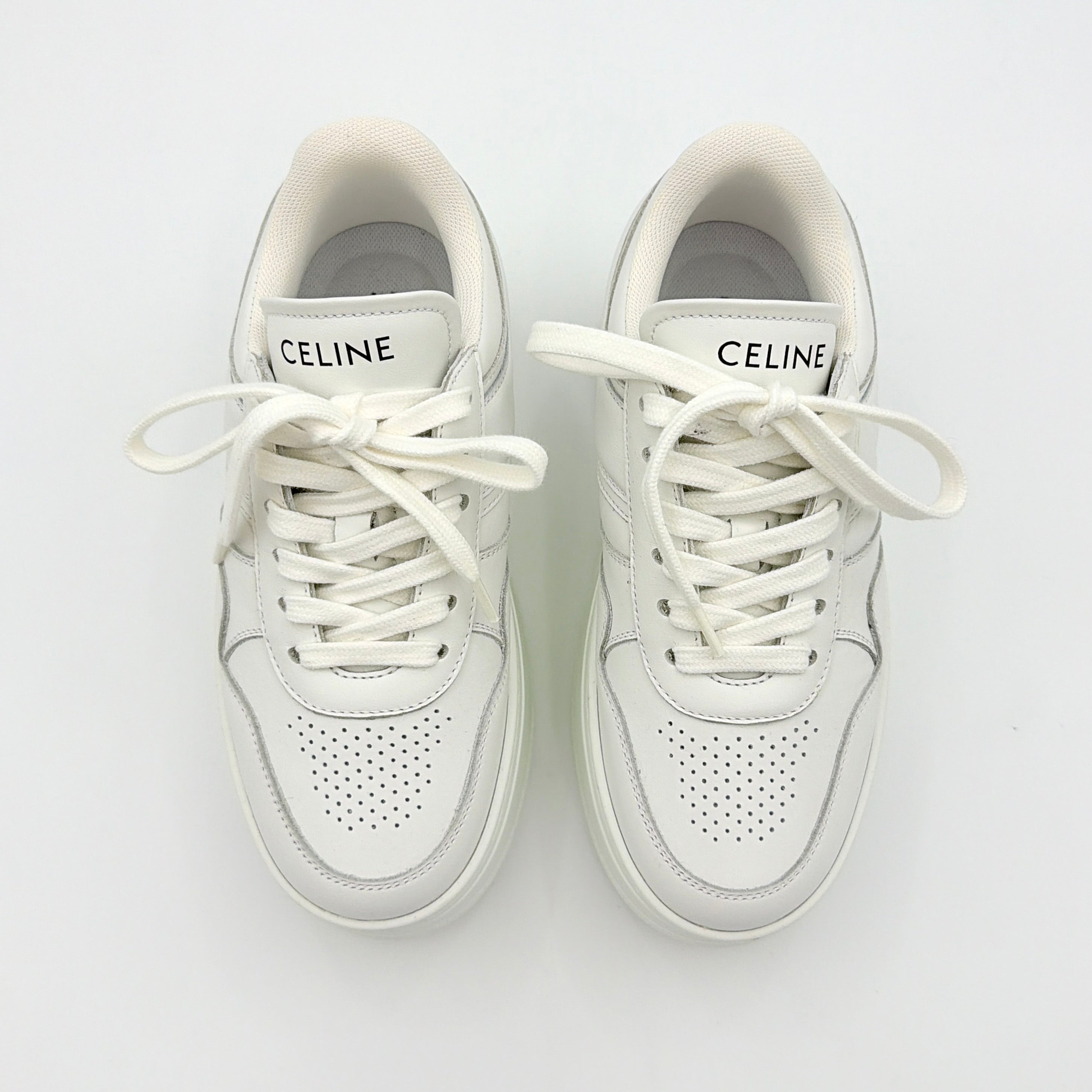 Celine white leather block platform sneakers with bold embossed sole and lace-up front, displayed at a slight angle.