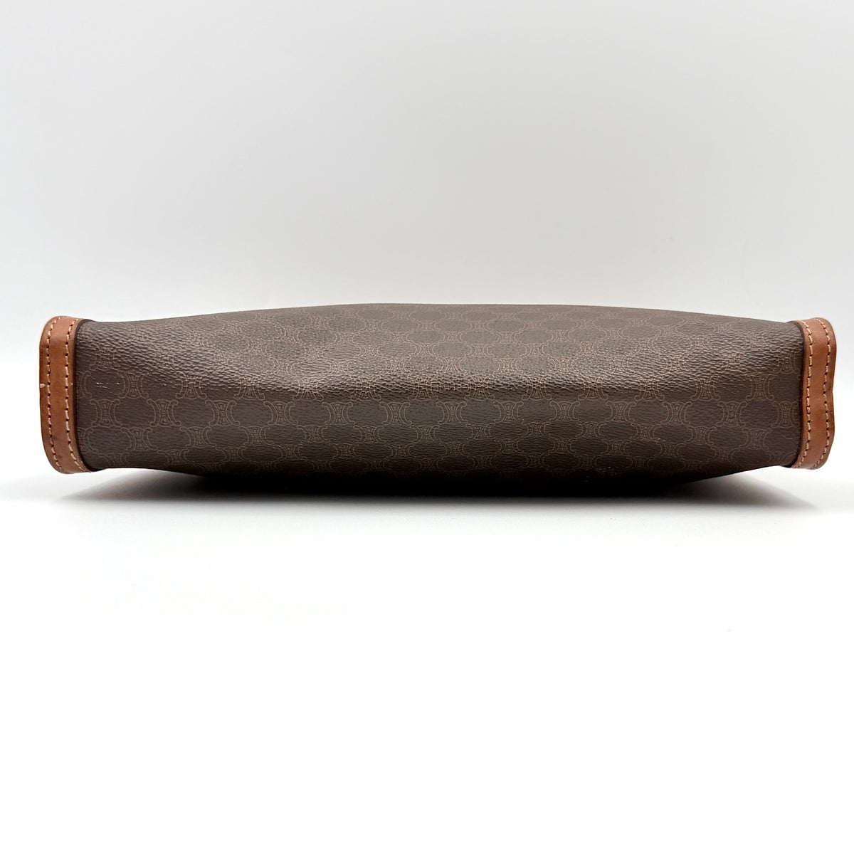 Celine Triomphe Macadam Clutch Bag in brown coated canvas with tan leather trim and gold zip, displayed against a white background.
