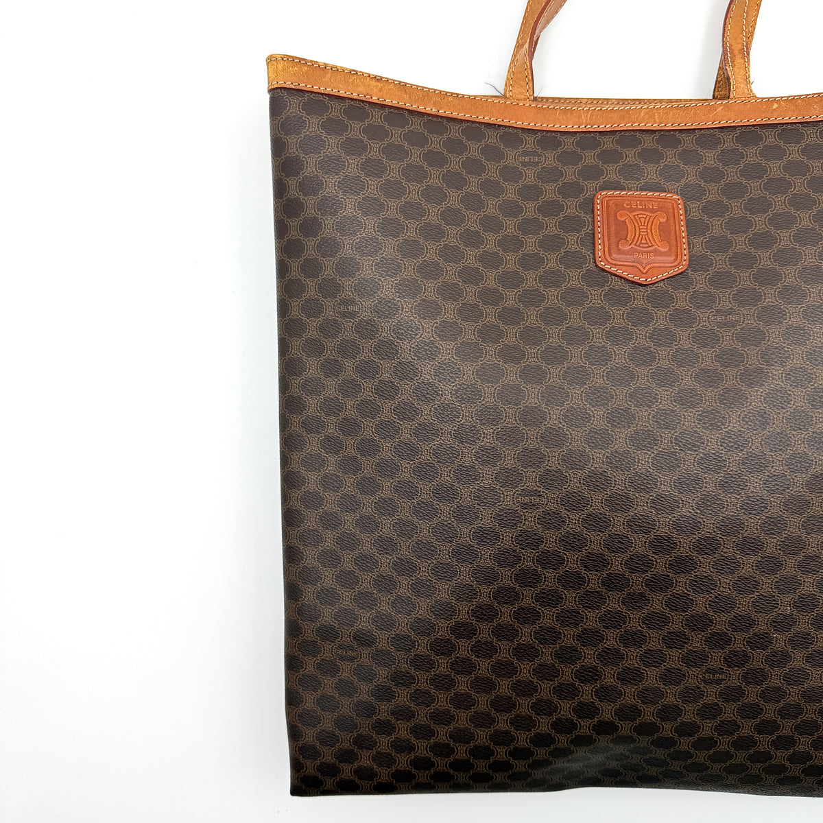 Front view of the Celine Triomphe Macadam Tote Bag in brown coated canvas with tan leather detailing and double handles.