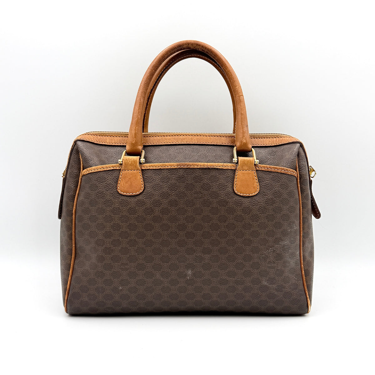 Celine Triomphe Macadam Boston Bag in brown coated canvas with tan leather trim and top handles, photographed against a white background.