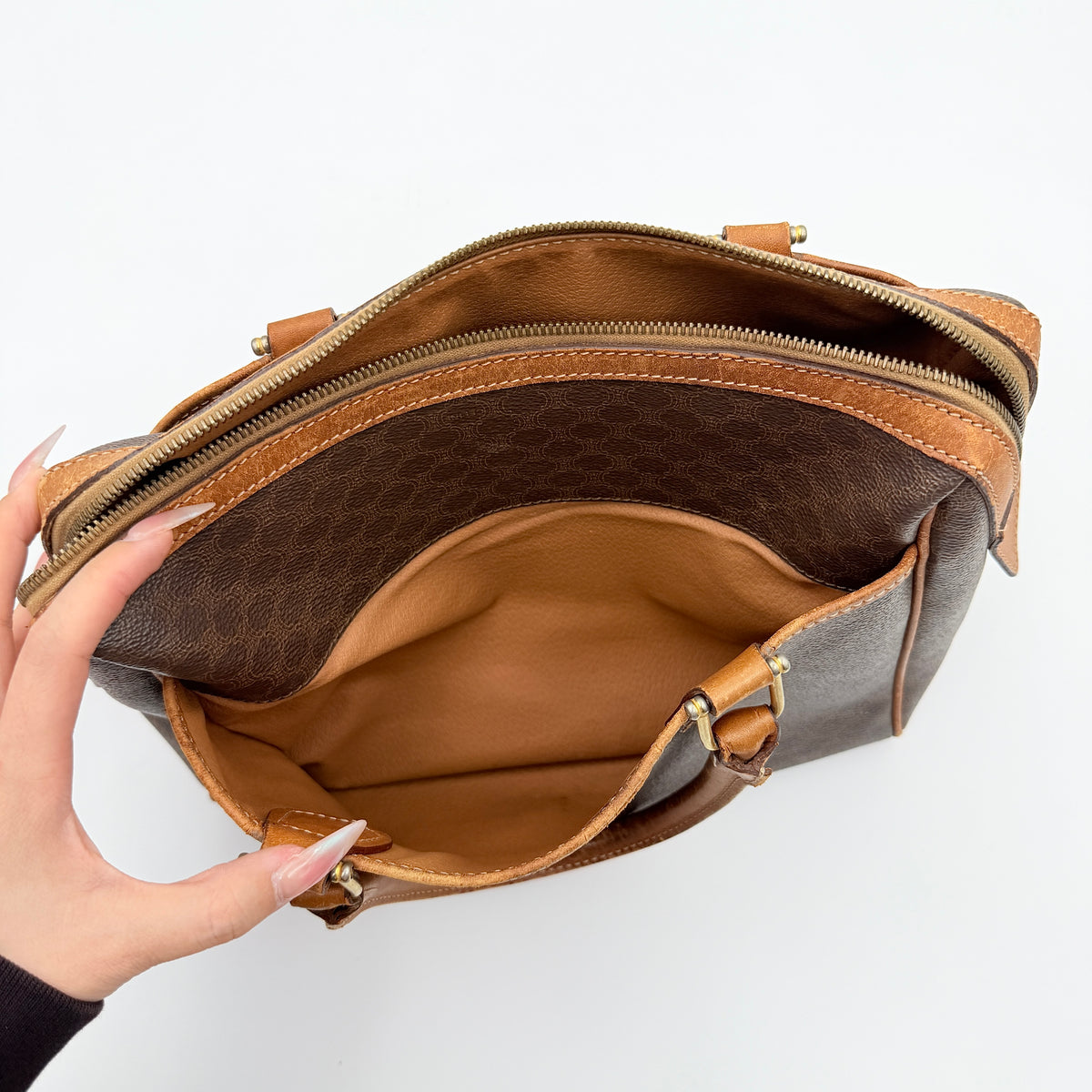 Celine Triomphe Macadam Boston Bag in brown coated canvas with tan leather trim and top handles, photographed against a white background.