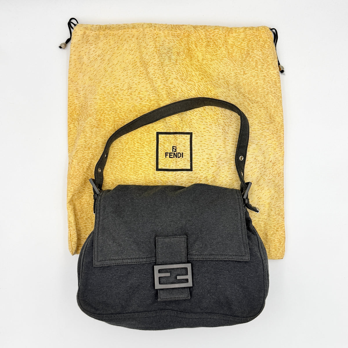 Fendi Mamma Baguette in grey textile with matte FF plaque, shown with original yellow Fendi dust bag.