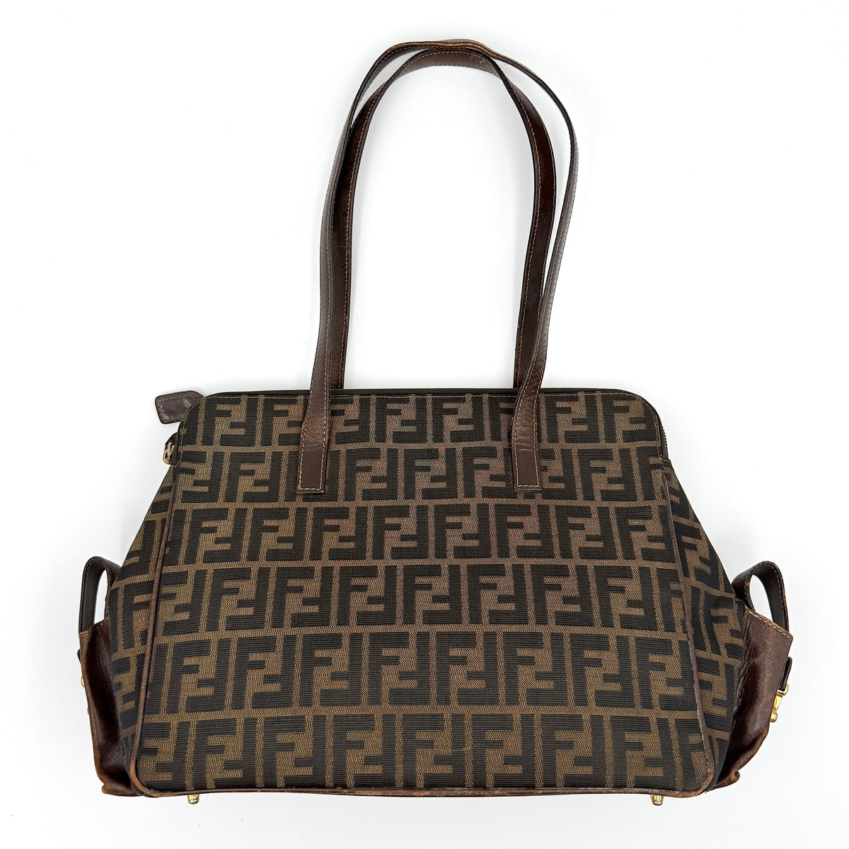 Fendi FF Zucca Double Zip Tote Bag in brown monogram canvas with leather straps and side pocket detail, shown on a yellow dust bag.