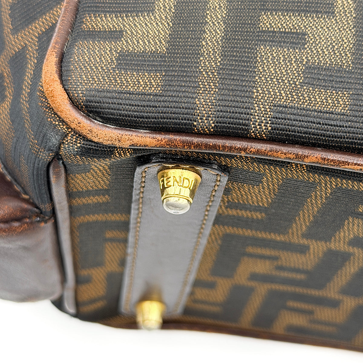 Fendi FF Zucca Double Zip Tote Bag in brown monogram canvas with leather straps and side pocket detail, shown on a yellow dust bag.